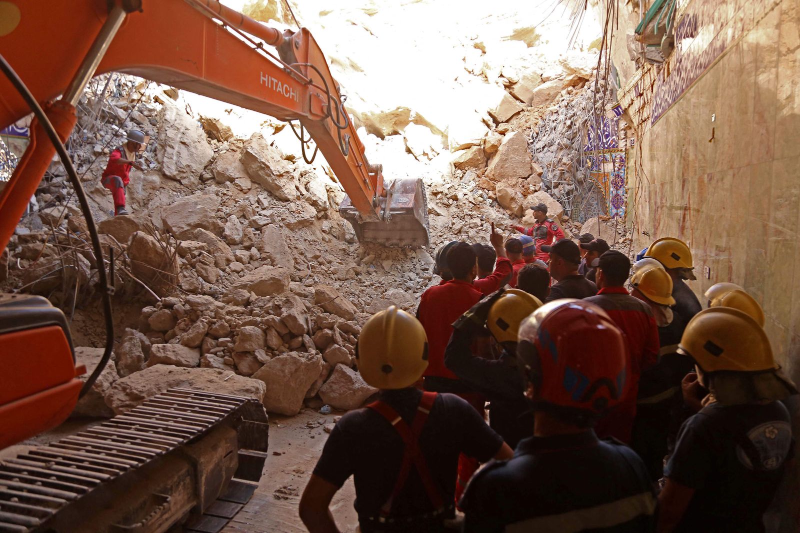 Iraqi rescue workers search for survivors trapped under the rubble of the Qattarat al-Imam Ali shrine following a landslide, on the outskirts of the holy city of Karbala on August 21, 2022. - Between six and eight pilgrims had been reported trapped under the debris of the shrine, known as Qattarat al-Imam Ali, civil defence spokesman Nawas Sabah Shaker had said earlier. (Photo by Mohammed SAWAF / AFP) - AFP