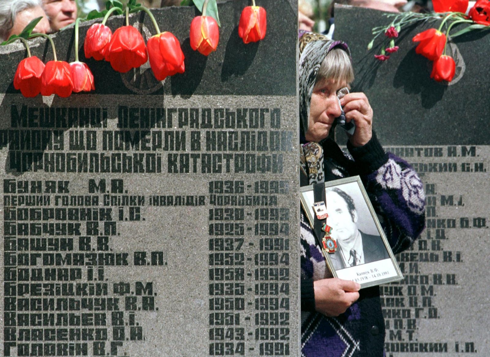 سيدة أوكرانية تبكي أمام نصب تذاري لضحايا كارثة 