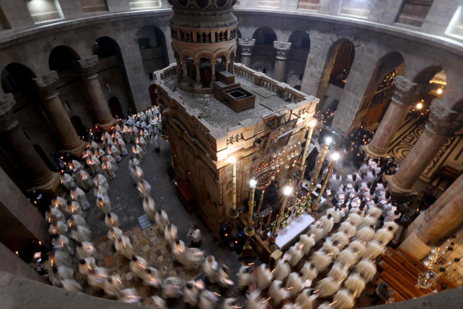 Christian worshippers, monks, and friars walk in procession around the Edicule, traditionally believed to be the burial site of Jesus Christ, during a mass to commemorate the Washing of the Feet on Holy Thursday, at the Church of the Holy Sepulchre in Jerusalem, on April 1, 2021. - Holy Thursday or Maundy Thursday is the Christian day falling before Easter which commemorates the Washing of the Feet and the Last Supper of Jesus Christ with the apostles. (Photo by Emmanuel DUNAND / AFP) - AFP