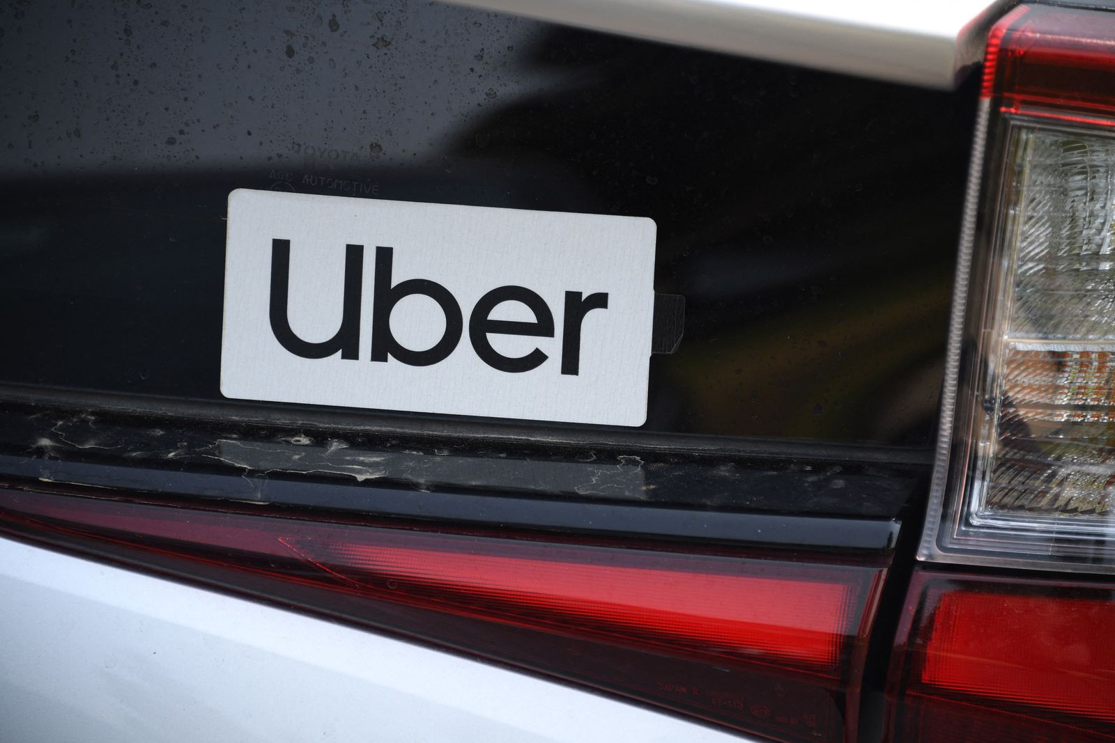 (FILES) In this file photo taken on August 20, 2020 an Uber sticker is seen on a car at the start of a protest by ride share drivers in Los Angeles, California. - Uber on May 5, 2021 reported that it narrowed its quarterly loss by selling its self-driving tech unit and said its pandemic-battered ride share business is starting to regain speed. (Photo by Robyn Beck / AFP) - AFP