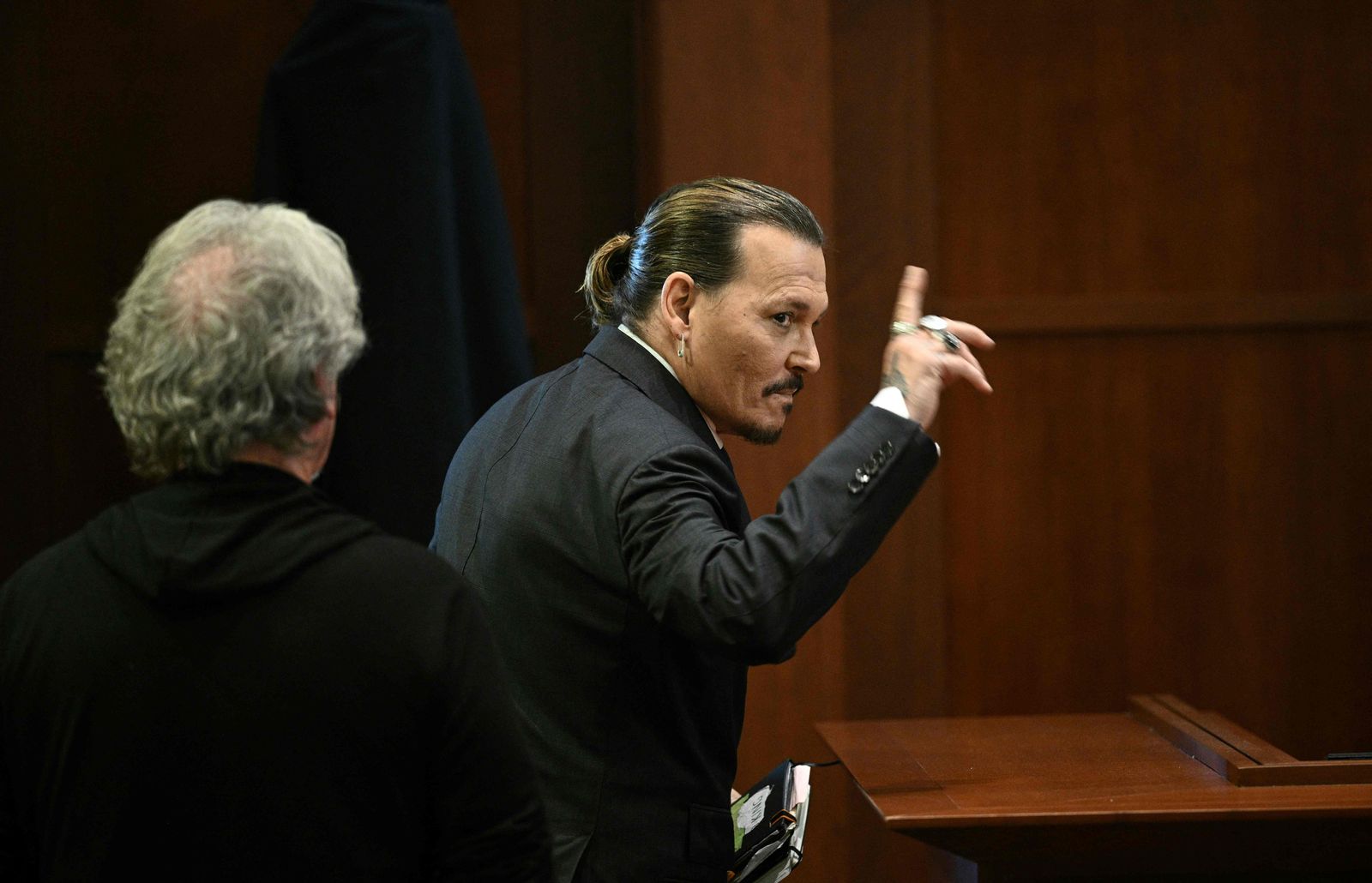 US actor Johnny Depp gestures as he departs the courtroom for a break at the Fairfax County Circuit Courthouse in Fairfax, Virginia, on May 17, 2022. - Actor Johnny Depp is suing ex-wife Amber Heard for libel after she wrote an op-ed piece in The Washington Post in 2018 referring to herself as a �public figure representing domestic abuse.� (Photo by BRENDAN SMIALOWSKI / POOL / AFP) - AFP