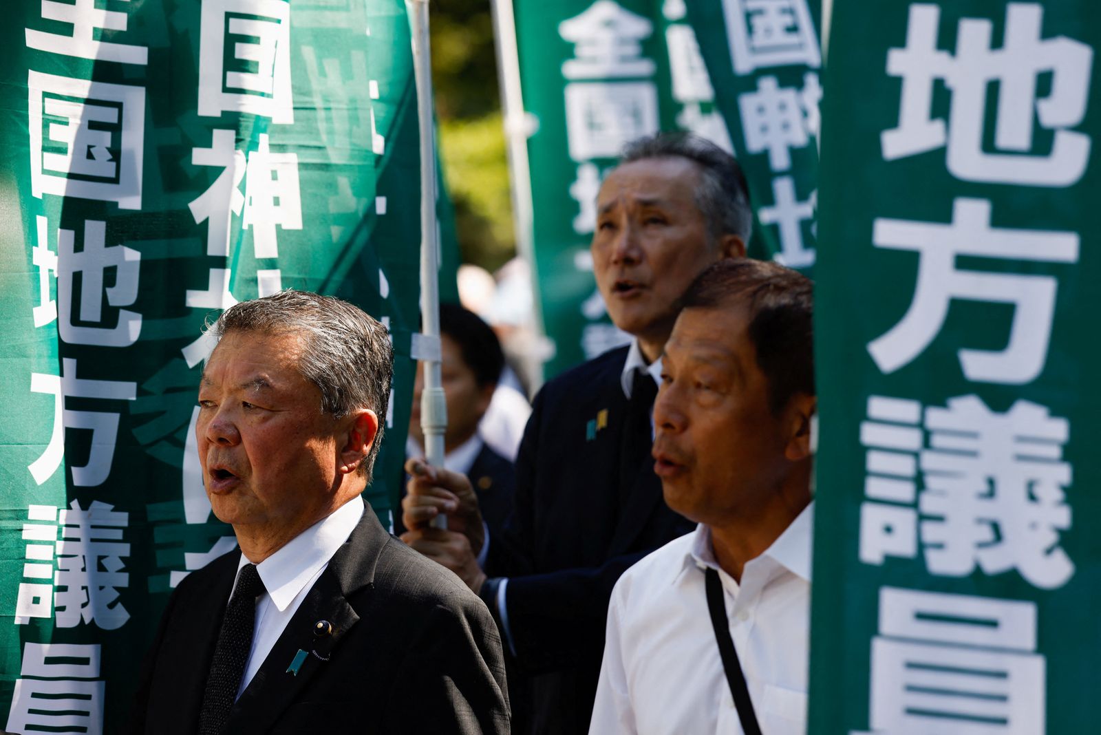 Members of the national organisation of local councillors sing the national anthem during their visit to the Yasukuni Shrine on the 80th anniversary of Japan's surrender in World War Two, in Tokyo, Japan, August 15, 2025. REUTERS/Manami Yamada