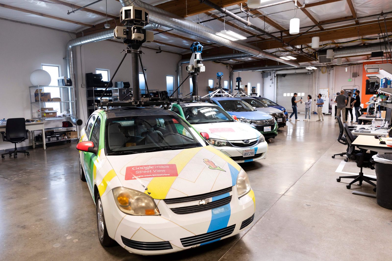 Several generations of Google Street View Cars are lined up on display at the Google Street View Garage in Mountain View, California on August 29, 2022. - 2022 marks the 15th anniversary of Google Maps� Street View. (Photo by Brittany Hosea-Small / AFP)