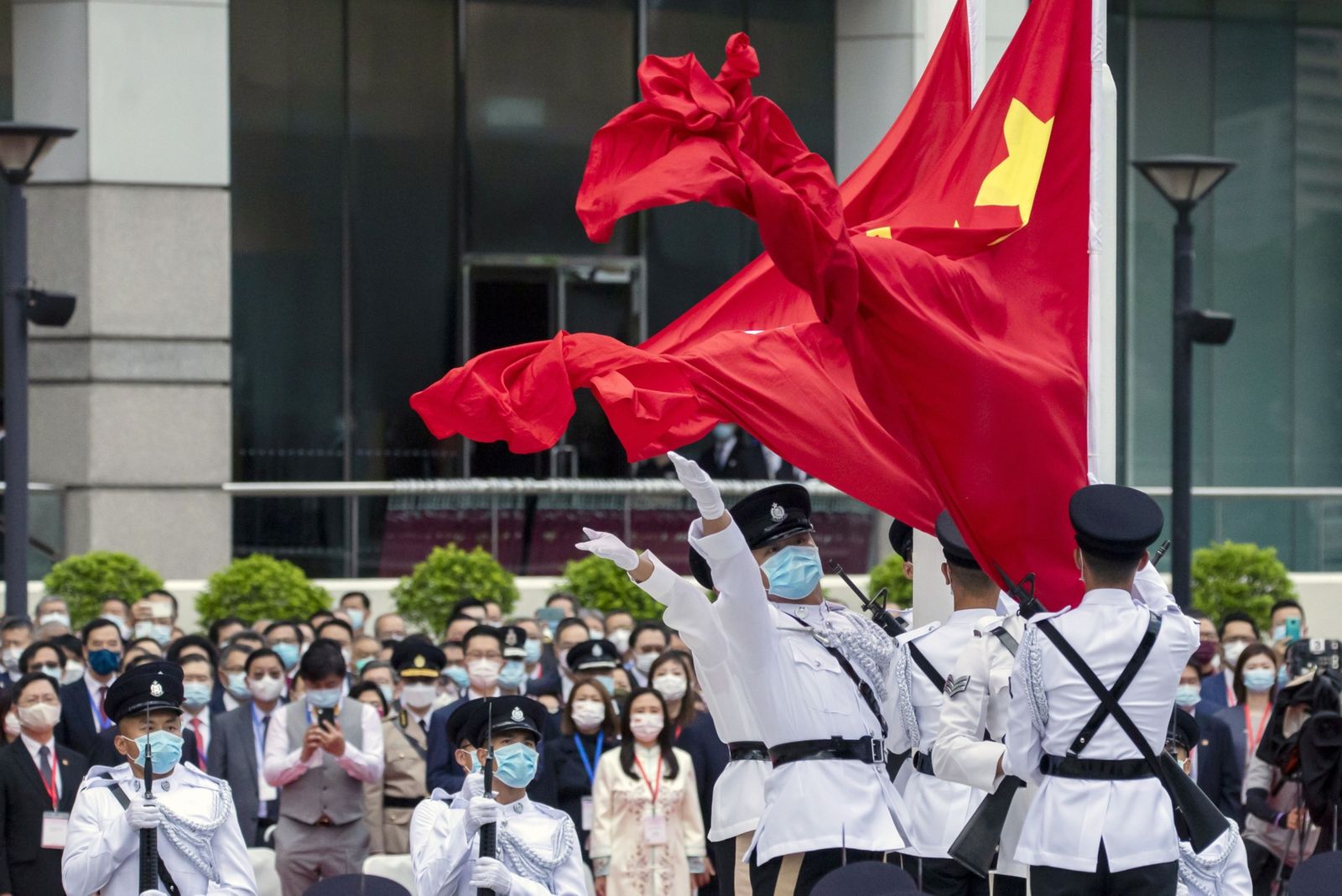حرس شرف تابعون لشرطة هونغ كونغ يرفعون علمَي المدينة والصين خلال احتفال بذكرى عودة هونغ كونغ إلى الحكم الصيني - 1 يوليو 2021 - Bloomberg
