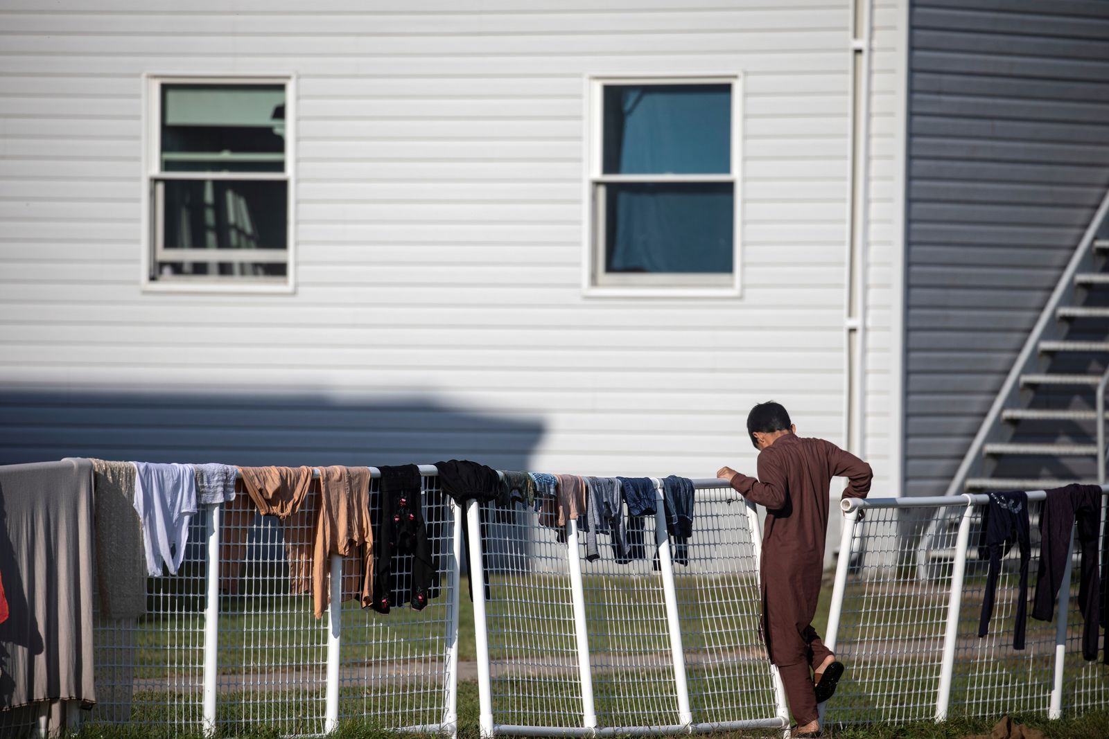 طفل أفغاني أمام مسكن مؤقت في قاعدة 