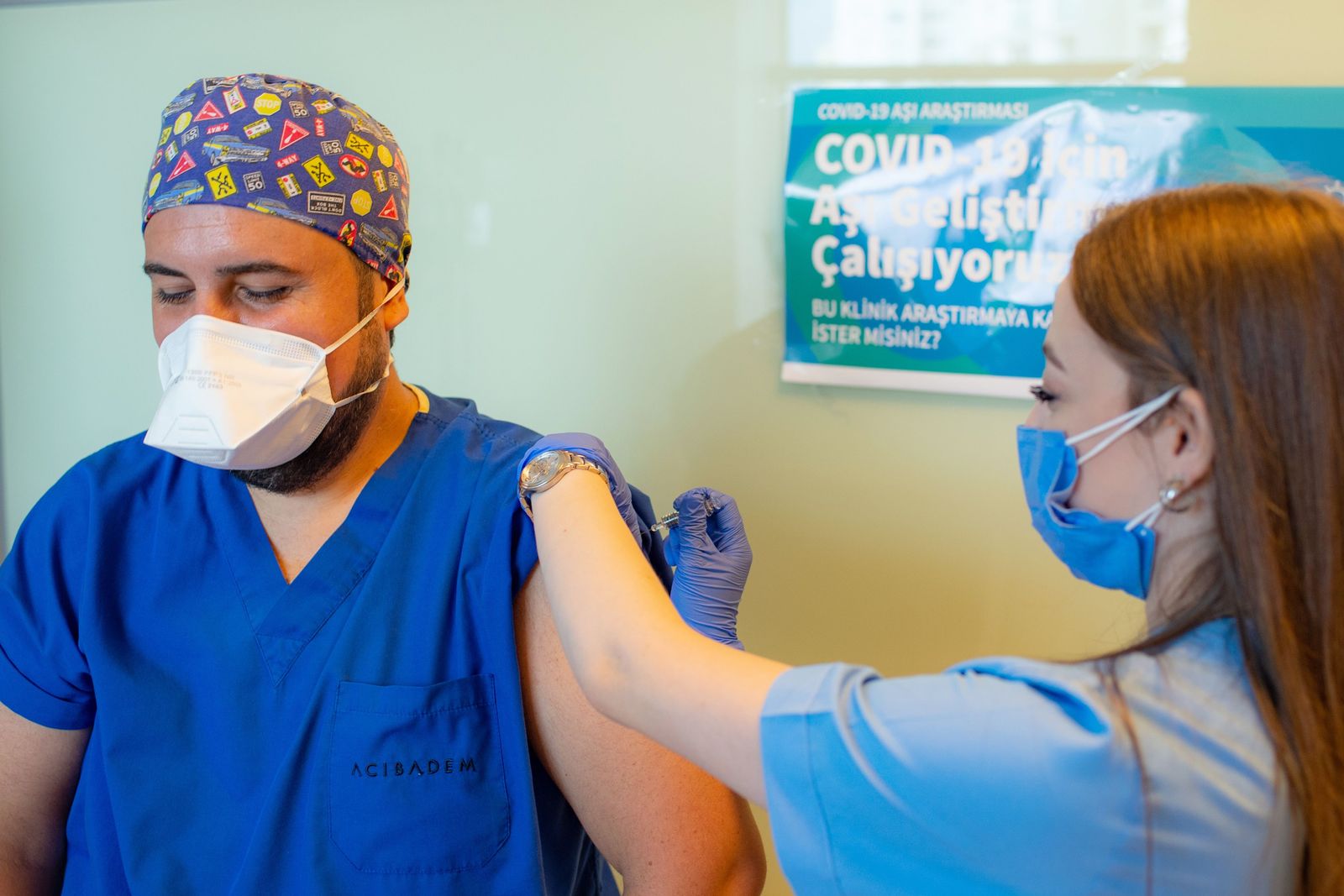 A health worker administers a dose of Sinovac Biotech potential vaccine against the COVID-19 to Doctor Cem Gun (L) during the 3rd phase trials at the Acibadem Hospital in Istanbul, on October 9, 2020.Y (Photo by Yasin AKGUL / AFP) - AFP