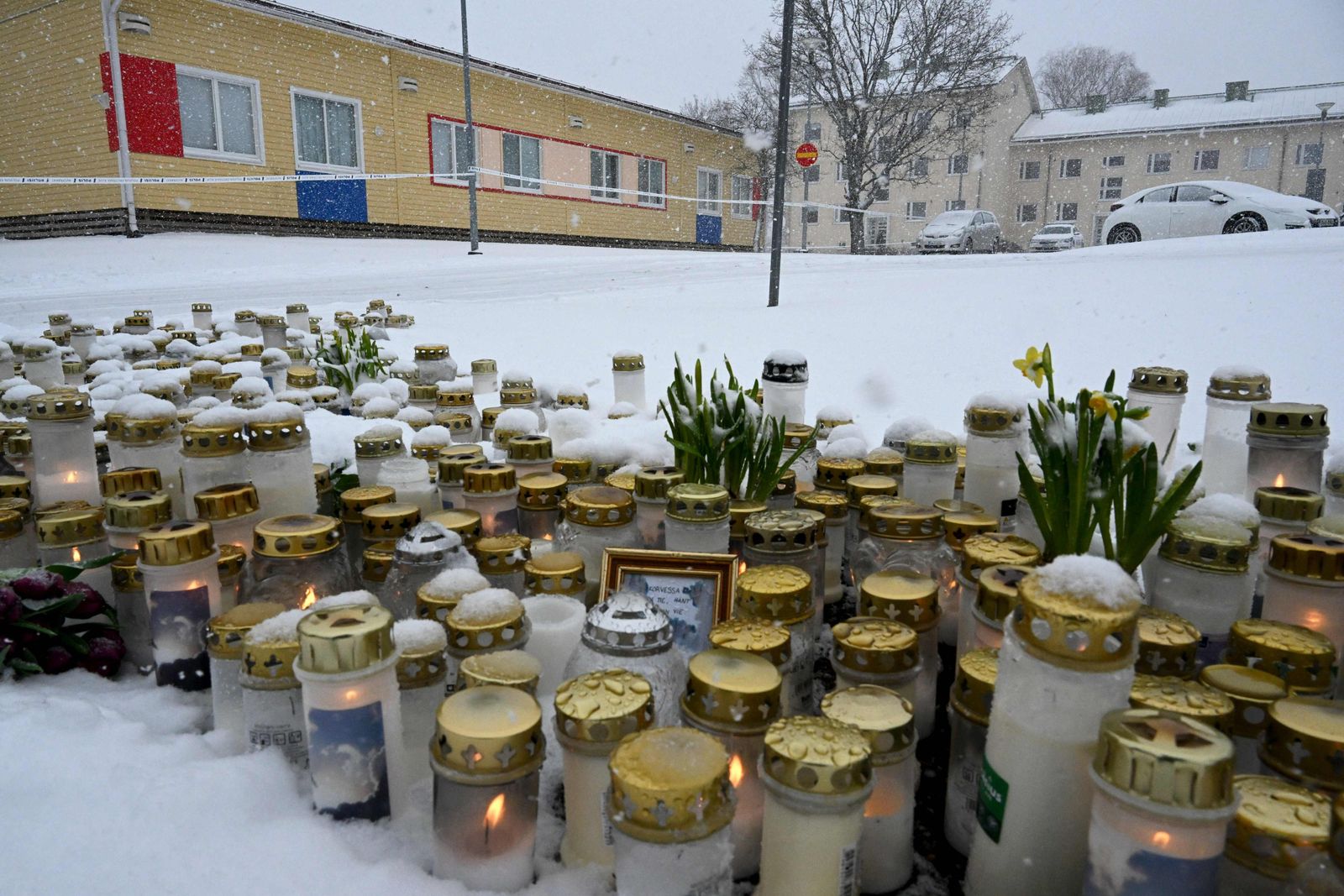 Candles and flowers are placed on a square in front of the Viertola School to pay tribute to victims in Vantaa, in the north of  the Finnish capital Helsinki, on April 3, 2024, one day after a 12-year-old opened fire inside the school, killing a classmate and seriously injuring two other children. Finland will fly its flags at half-mast on April 3, 2024, to mark the country's mourning after a 12-year-old opened fire at a school, killing one classmate and seriously injuring two others in the city of Vantaa. (Photo by Jussi Nukari / Lehtikuva / AFP) / Finland OUT