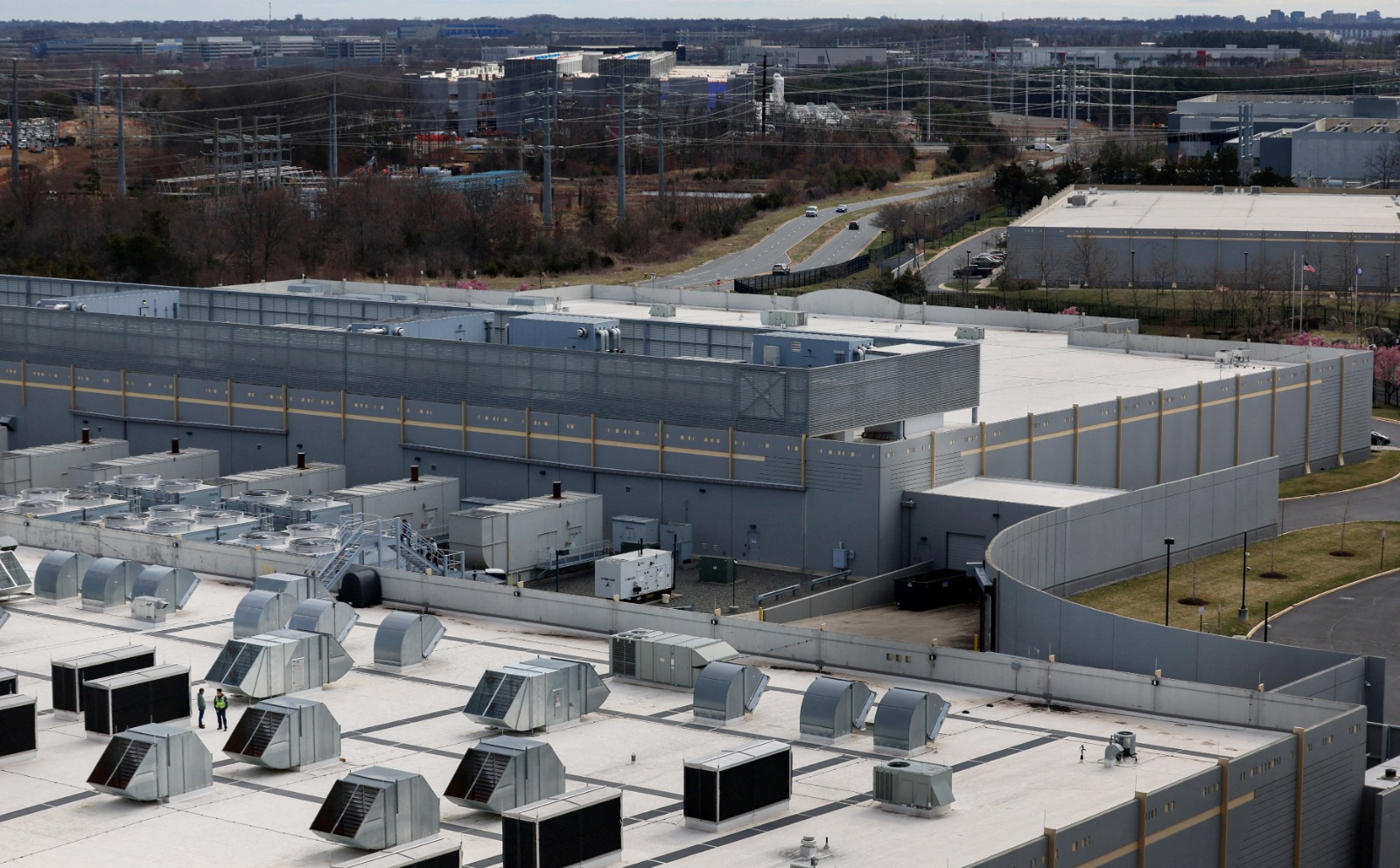 سيارات تمر بجانب مباني مركز بيانات 'Digital Realty' في أشبورن بولاية فرجينيا- 17 مارس/آذار 2025