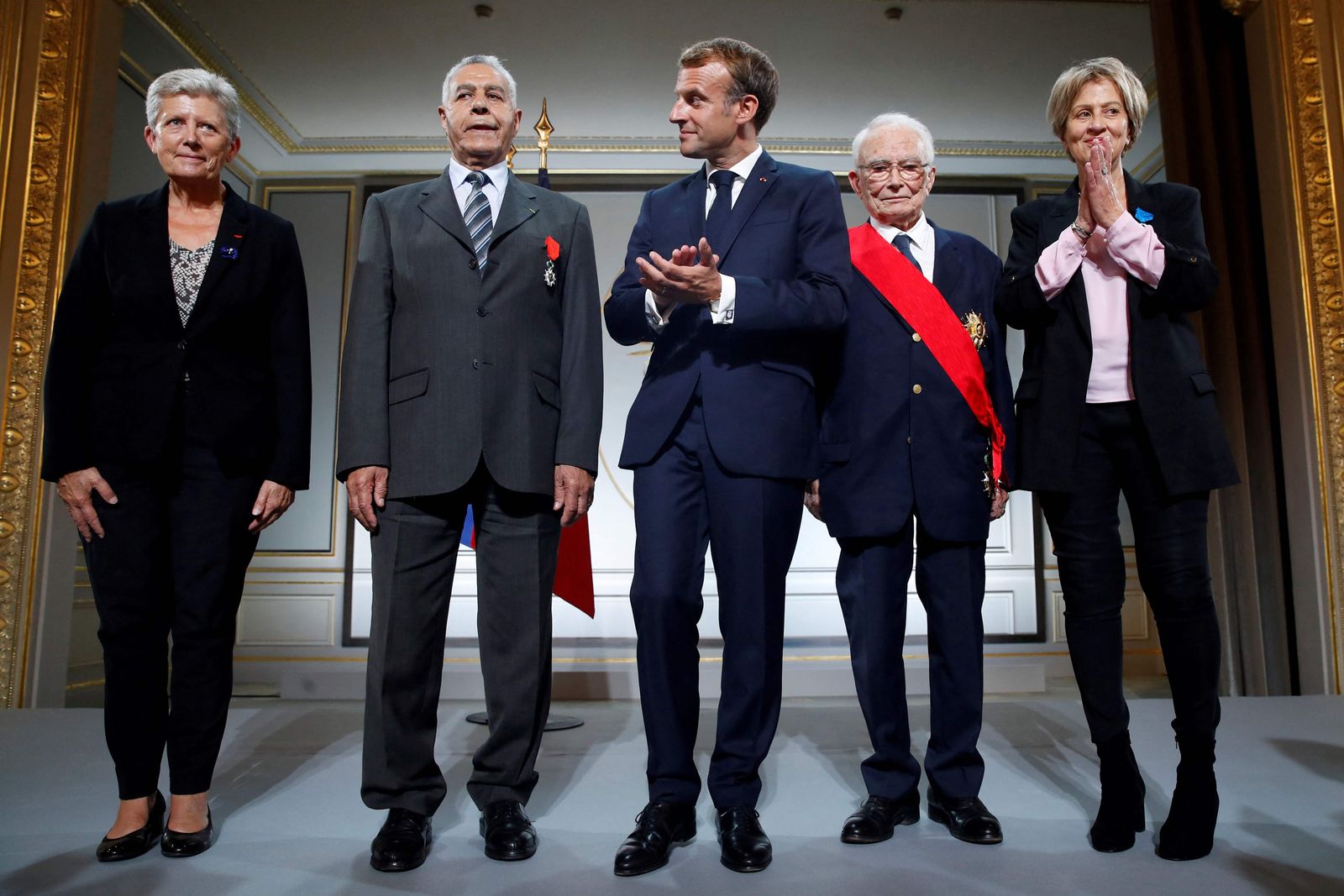 General Francois Meyer (2ndR), Salah Abdelkrim (2ndL) and Bornia Tarall (R) pose with French President Emmanuel Macron (C) and Junior Minister for Defence Genevieve Darrieussecq (L) after being awarded during a ceremony in memory of the Harkis, Algerians who helped the French Army in the Algerian War of Independence, at the Elysee Palace in Paris, on September 20, 2021. (Photo by GONZALO FUENTES / POOL / AFP) - AFP