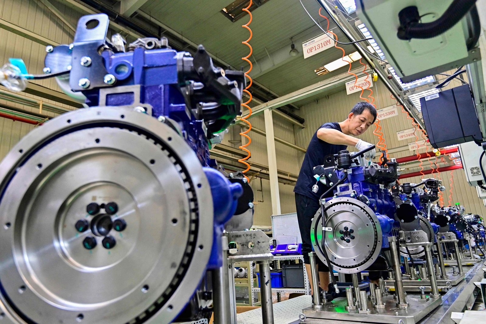 This photo taken on August 31, 2023 shows a worker assembling an engine at an engine manufacturing factory in Qingzhou, in China's eastern Shandong Province. (Photo by AFP) / China OUT - AFP