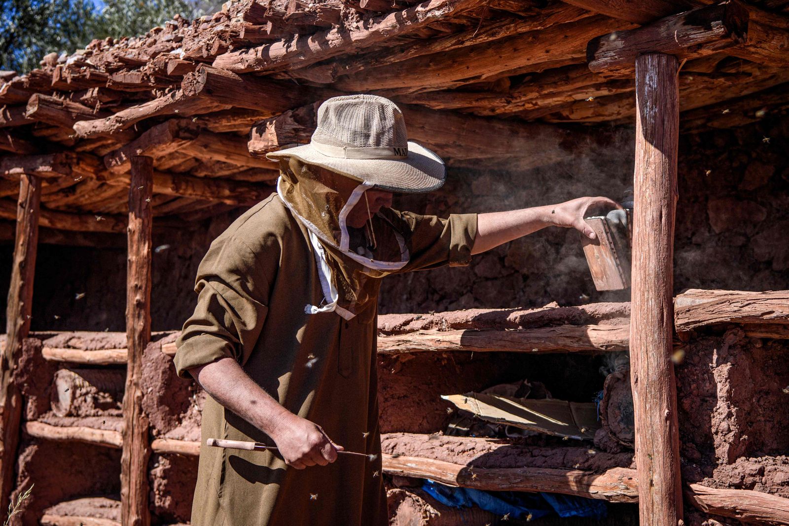 (FILES) In this file photo taken on February 26, 2020, a beekeeper works at the Inzerki Apiary in the village of Inzerki, 82 km north of Agadir, in the Souss-Massa region. - Morocco's village of Inzerki proudly claims to have the world's oldest and largest collective beehive, but instead of buzzing with springtime activity, the colonies have collapsed amid crippling drought. (Photo by FADEL SENNA / AFP) - AFP