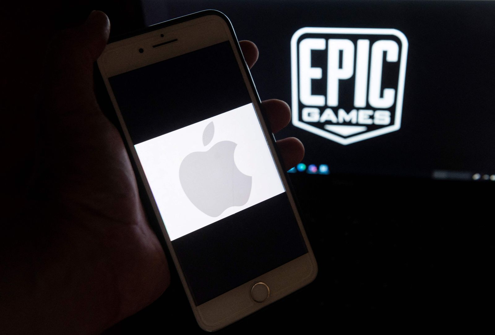 (FILES) In this file illustration photo taken on April 30, 2021 the logo from Epic Games is displayed on a laptop and an Apple Logo on an iPhone in Arlington, Virginia. - A US judge on November 9, 2021 rejected Apple's request to delay letting App Store offerings bypass its payment system as ordered by the court, saying it had 30 days to comply in a case brought by Epic Games, the creator of Fortnite. (Photo by Andrew CABALLERO-REYNOLDS / AFP) / RESTRICTED TO EDITORIAL USE - AFP