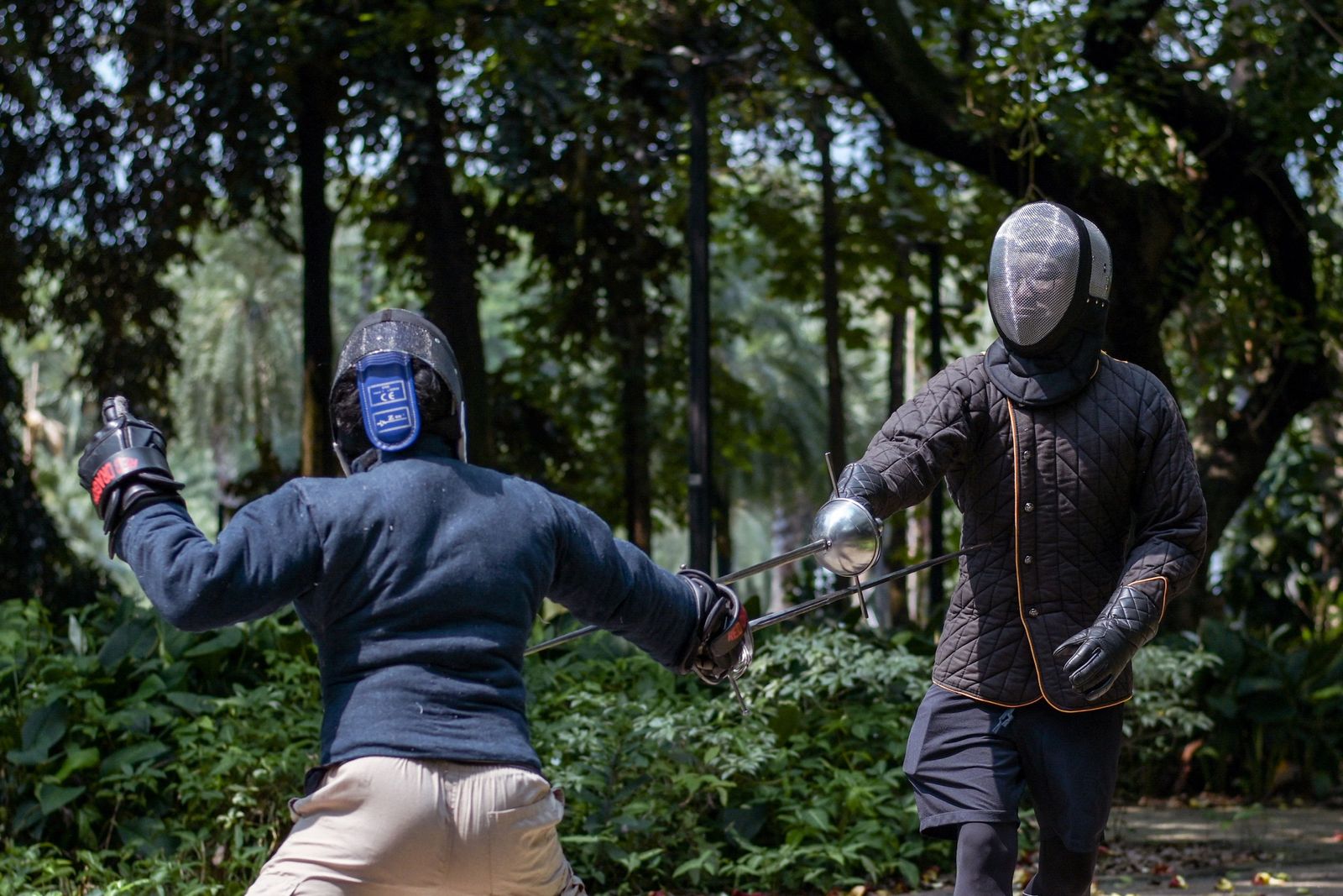 This picture taken on July 24, 2022 shows members of the Gwaith-i-Megyr group practicing sword-fighting techniques known as Historical European Martial Arts (HEMA) at a park in Jakarta. - Armed with blunt swords, a dozen would-be chevaliers are put through their paces in a gallant effort to keep alive European medieval martial arts taught hundreds of years ago. (Photo by BAY ISMOYO / AFP) / To go with AFP story Indonesia-lifestyle-hobby by Marchio GORBIANO - AFP