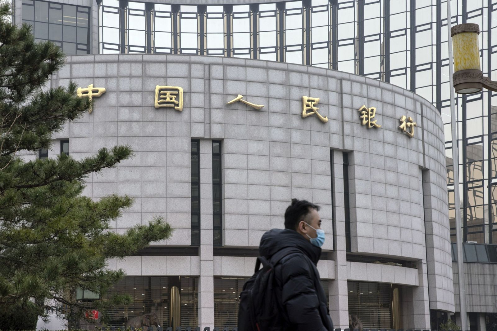 يسير أمام مقرّ المصرف المركزي الصيني في بكين - 4 مارس 2021 - Bloomberg