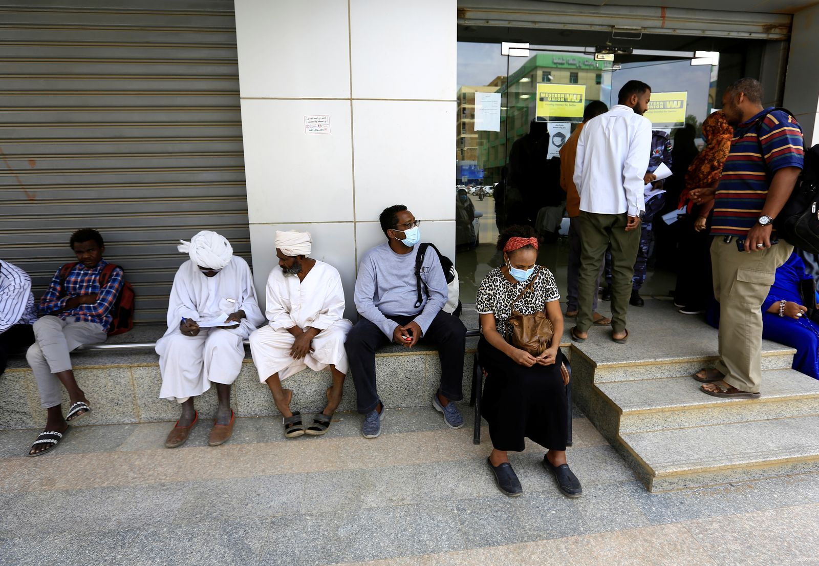 أشخاص ينتظرون خارج مكتب لصرف العملات في الخرطوم، 28 فبراير 2021 - REUTERS