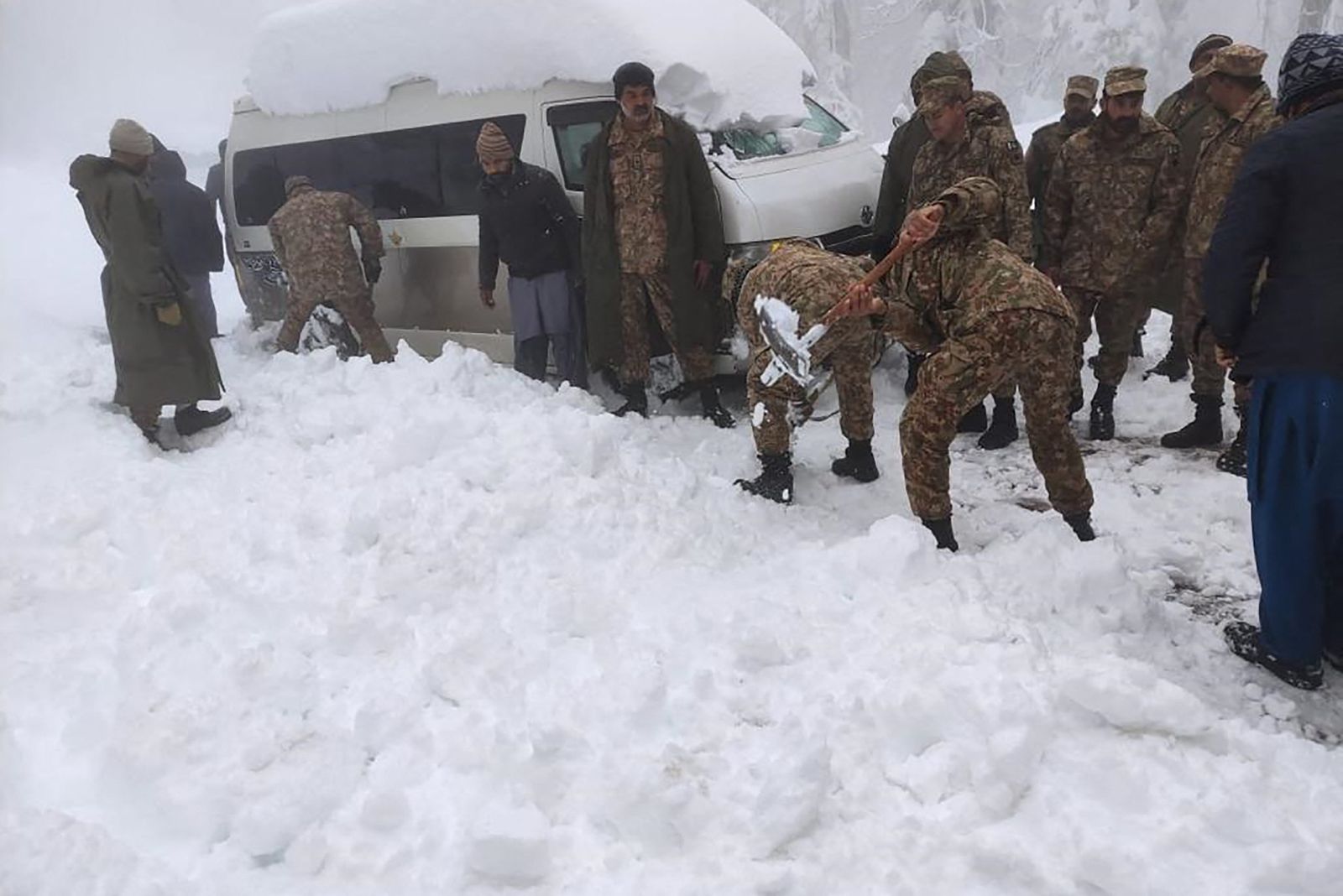 محاولة سحب إحدى السيارات العالقة في الثلوج في باكستان - 8 يناير 2022 - AFP