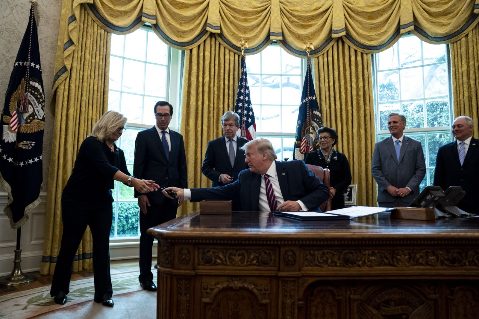 الرئيس الأميركي دونالد ترمب يعطي النائبة الجمهورية ليز تشيني قلماً في البيت الأببض - 24 أبريل 2020   - Bloomberg