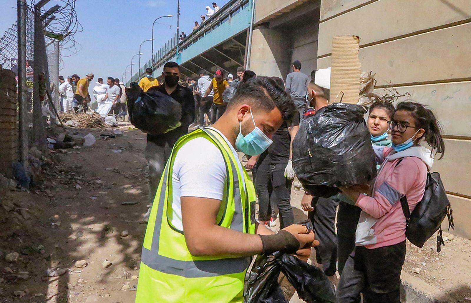 Young Iraqi volunteers take part in a clean-up campaign on the bank of the Tigris river in the Adhamiyah district of the capital Baghdad, on March 11, 2022. - Plastic garbage clogs the banks of Iraq's Tigris River in Baghdad, but an army of young volunteers is cleaning it, a rare environmental project in the war-battered country, part of a green activist campaign called the Cleanup Ambassadors. (Photo by Sabah ARAR / AFP) - AFP