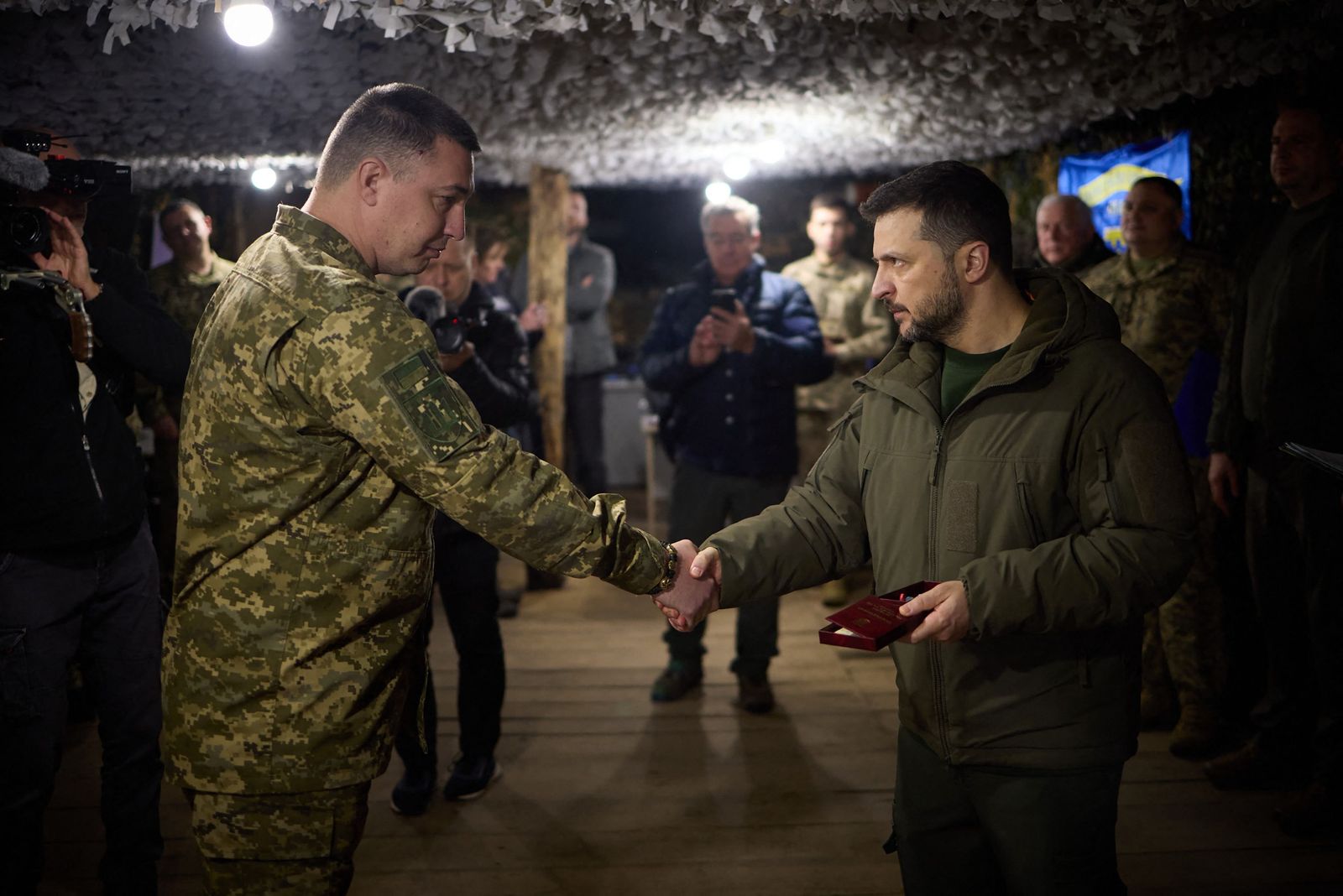 This handout photograph taken and released by Ukrainian Presidential press service on March 27, 2024, shows Ukraine's President Volodymyr Zelensky (R) awarding a Ukrainian serviceman on the location of the 117th separate brigade of territorial defence in the Sumy region, amid the Russian invasion in Ukraine. (Photo by Handout / UKRAINIAN PRESIDENTIAL PRESS SERVICE / AFP) / RESTRICTED TO EDITORIAL USE - MANDATORY CREDIT 'AFP PHOTO /Ukrainian Presidential press service ' - NO MARKETING NO ADVERTISING CAMPAIGNS - DISTRIBUTED AS A SERVICE TO CLIENTS