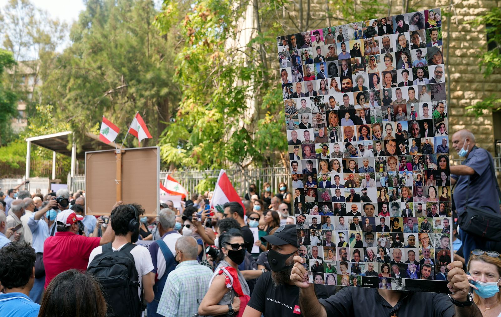متظاهر يحمل صور ضحايا انفجار ميناء بيروت عام 2020 خلال احتجاج أمام قصر العدل في بيروت، 29 سبتمبر 2021 - REUTERS