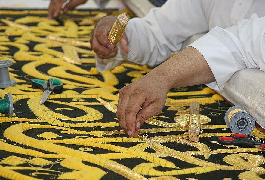 جانب من عمل موظفي مجمع الملك عبدالعزيز لكسوة الكعبة - 