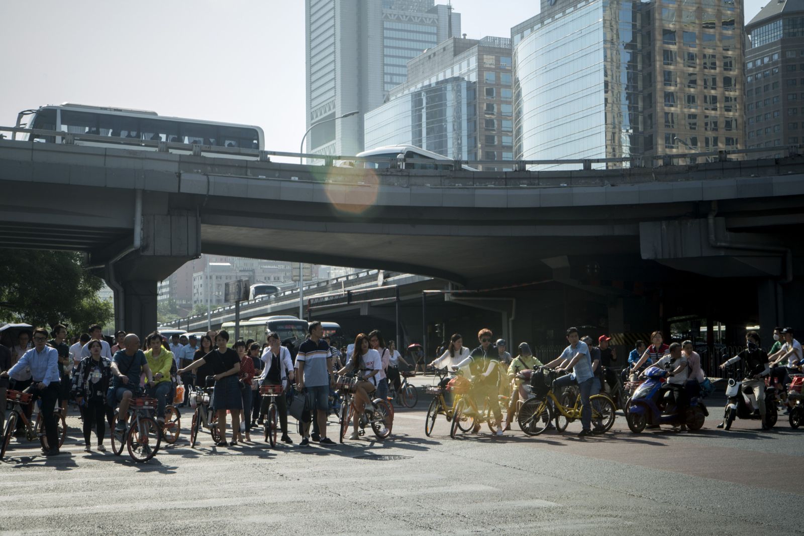 مشاة وراكبو دراجات ينتظرون عند تقاطع في حيّ الأعمال ببكين - 1 يونيو 2018 - Bloomberg