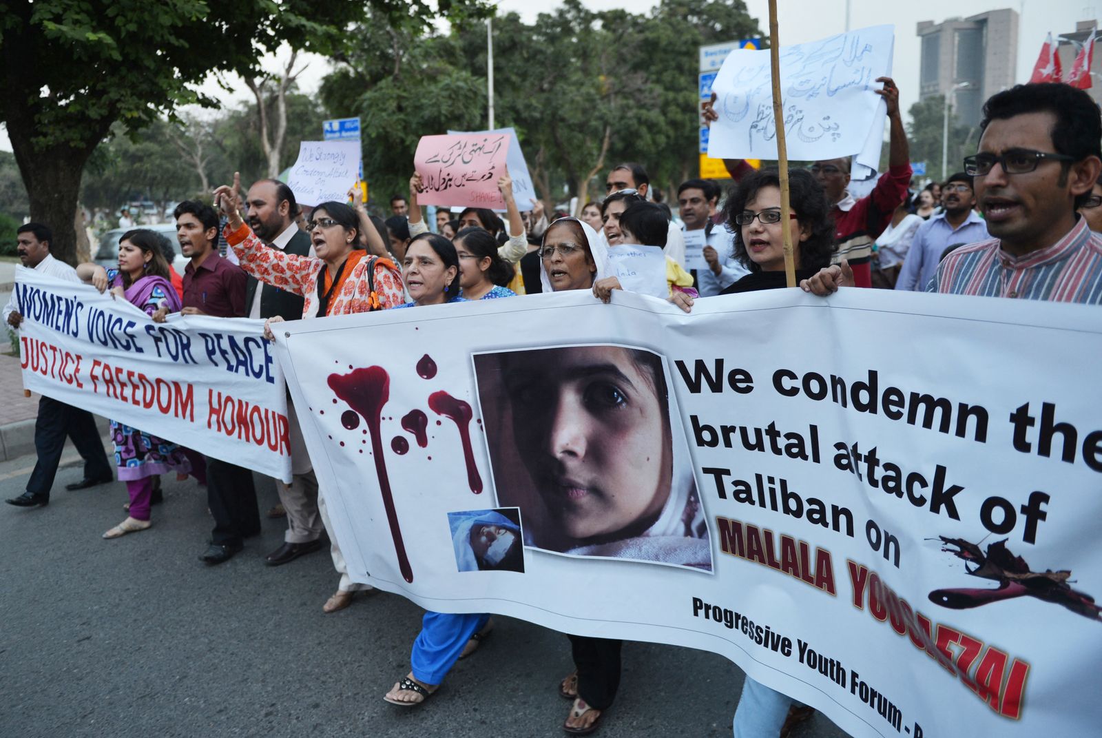 نشطاء وناشطات يرفعن صورة مالالا يوسف زاي خلال مظاهرة في إسلام أباد بعد تعرضها لمحاولة اغتيال من قبل حركة طالبان الباكستانية- 10 أكتوبر 2012 - AFP