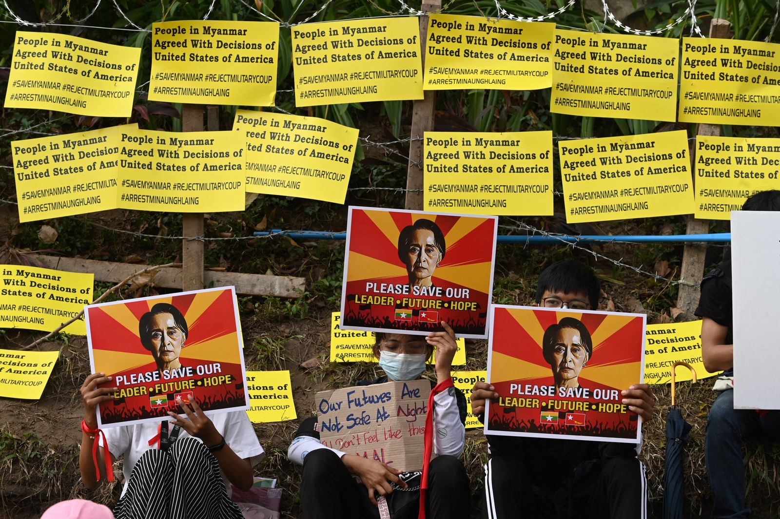 متظاهرون أمام السفارة الأميركية في يانغون يرفعون لافتات عليها صورة زعيمة ميانمار المحتجزة أونغ سان سو تشي ويطالبون بالإفراج عنها في 16 فبراير 2021  - AFP