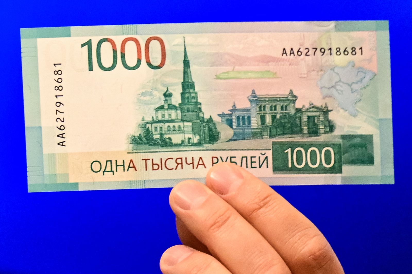 Deputy Governor of the Bank of Russia Sergey Belov holds the redesigned 1000-ruble banknote during its official presentation in Moscow on October 16, 2023. (Photo by Natalia KOLESNIKOVA / AFP)