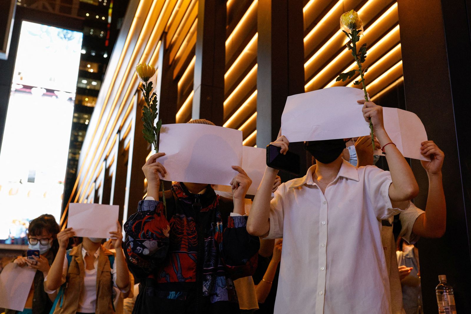 People hold white sheets of paper in protest over COVID-19 restrictions in mainland China, in Hong Kong - REUTERS