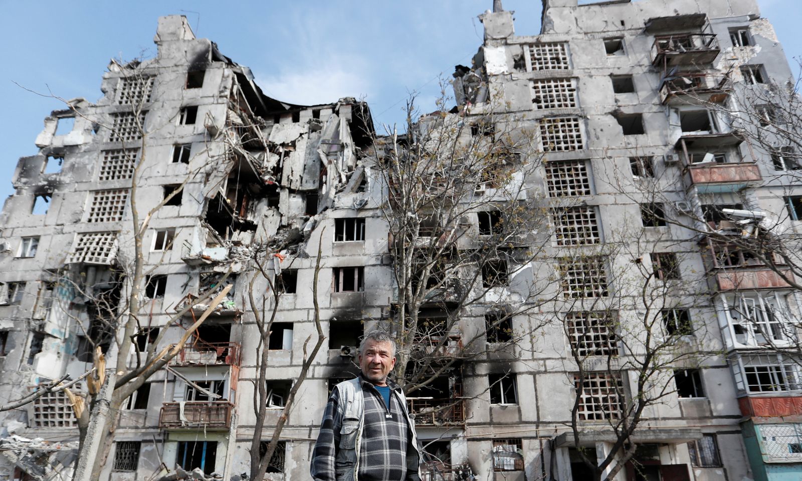 أوكراني يقف أمام مجمع سكني مدمر في ماريوبل الأوكرانية. 3 مايو 2022 - REUTERS