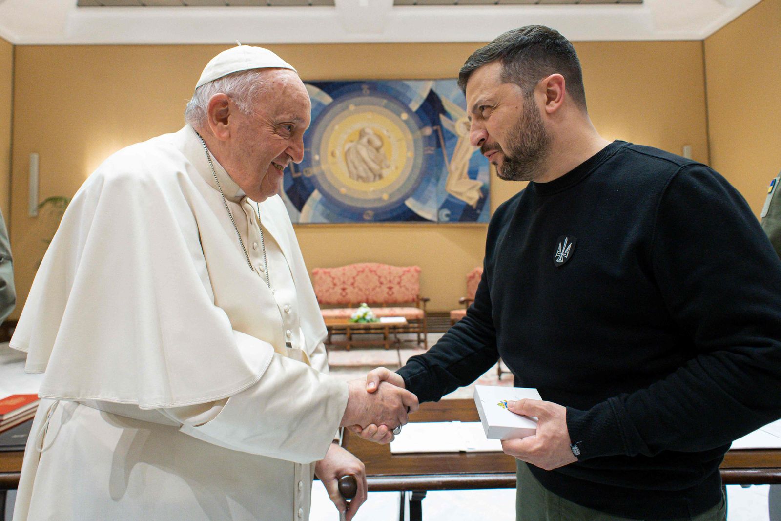 This photo taken and issued as a handout on May 13, 2023 by the Vatican Media shows Pope Francis shake hands with Ukrainian President Volodymyr Zelensky following a private audience in The Vatican. Ukrainian President Volodymyr Zelensky arrived in Rome on May 13 for meetings with President of Italy Sergio Mattarella, Prime Minister Giorgia Meloni and Pope Francis in his first visit to Italy since Russia's invasion. (Photo by Handout / VATICAN MEDIA / AFP) / RESTRICTED TO EDITORIAL USE - MANDATORY CREDIT 