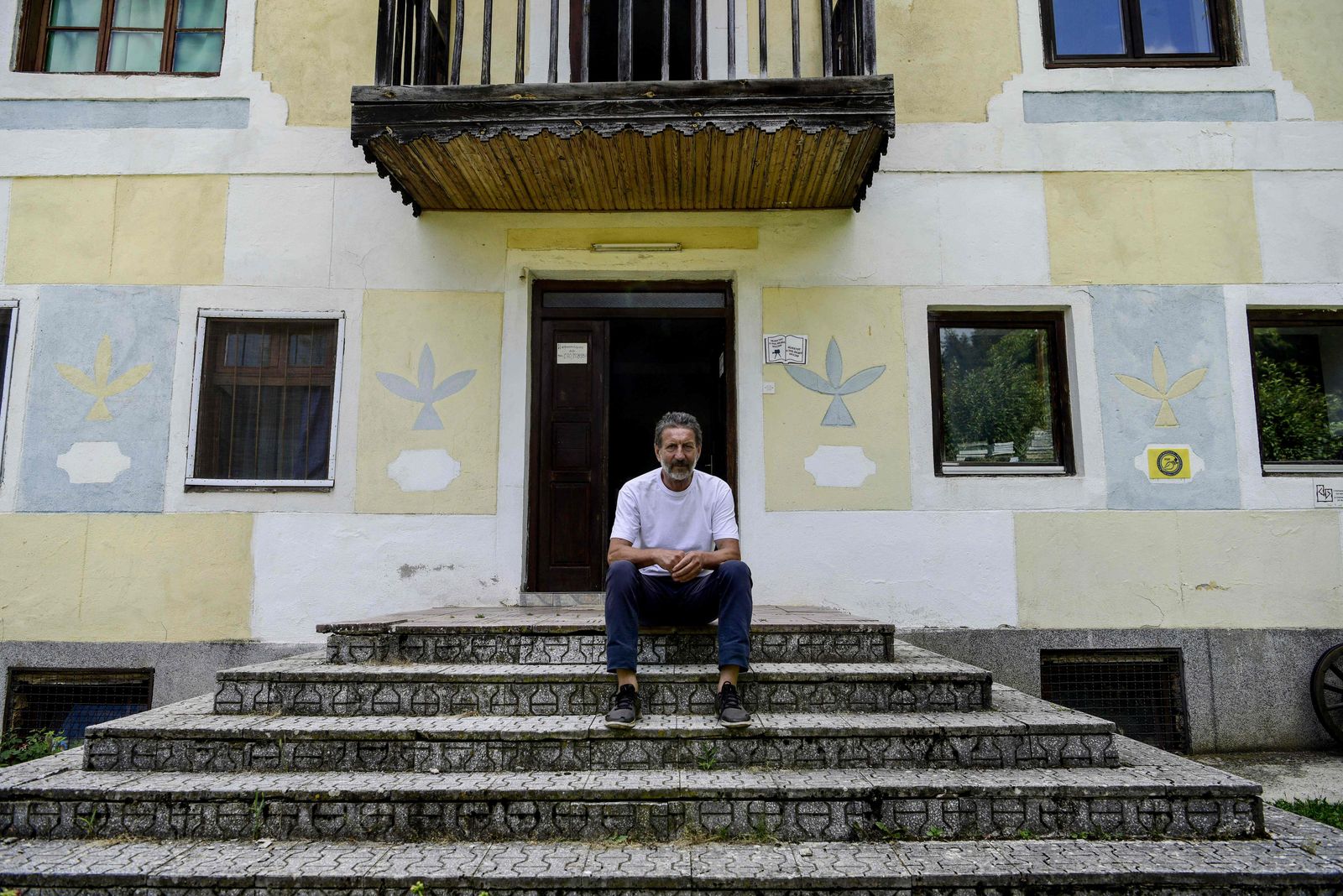 In this photograph taken on July 11, 2022, Stevo Stepanovski poses in front of his library in the village of Babino in western Macedonia - Most people packed up and left the remote North Macedonia village of Babino years ago. But Stevo Stepanovski and his remarkable collection of 20,000 books passed down in his family from generation to generation stayed put in his almost abandoned valley. The library began with Stepanovski's great-grandfather who was given his first tranche of books by passing Ottoman soldiers in the late 19th century. (Photo by Robert ATANASOVSKI / AFP) - AFP