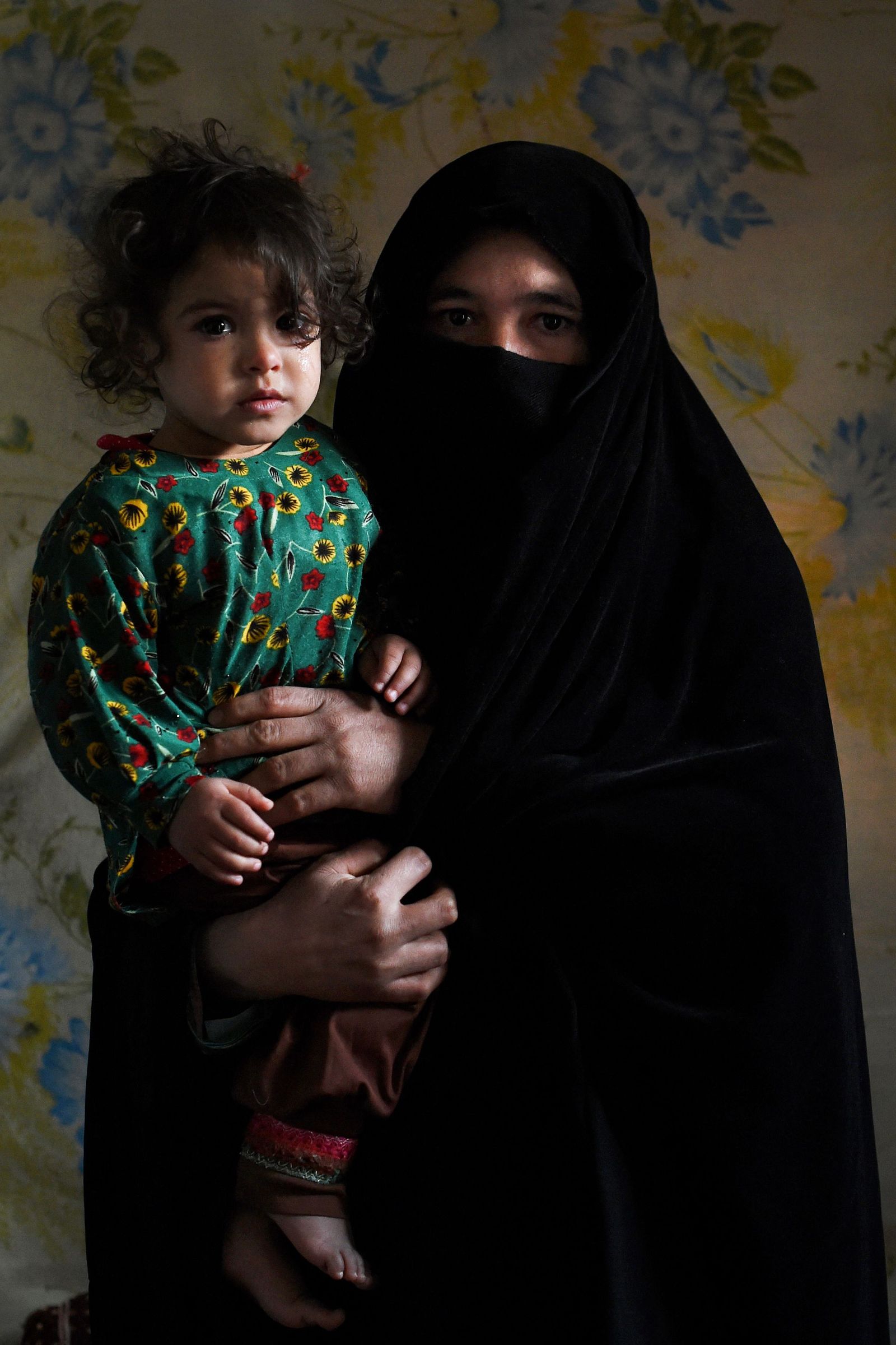 In this photo taken on February 3, 2022, Aziza, who plans to sell her kidney to raise money for her family, poses for a picture with her daughter Parwina at her house in Herat. - Jobless, debt ridden, and struggling to feed his children, Nooruddin felt he had no choice but to sell a kidney -- one of a growing number of Afghans willing to sacrifice an organ to save their families. (Photo by Wakil KOHSAR / AFP) / To go with AFP story Afghanistan-Economy-Health-Organs, FEATURE by Rouba EL HUSSEINI - AFP