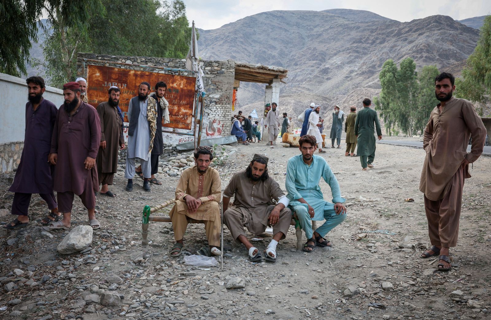 Victims of a deadly magnitude-6 earthquake that struck Afghanistan on Sunday, wait outside a mobile clinic setup inside a school, in Nurgal district, Kunar province, Afghanistan, September 3, 2025. REUTERS/Sayed Hassib