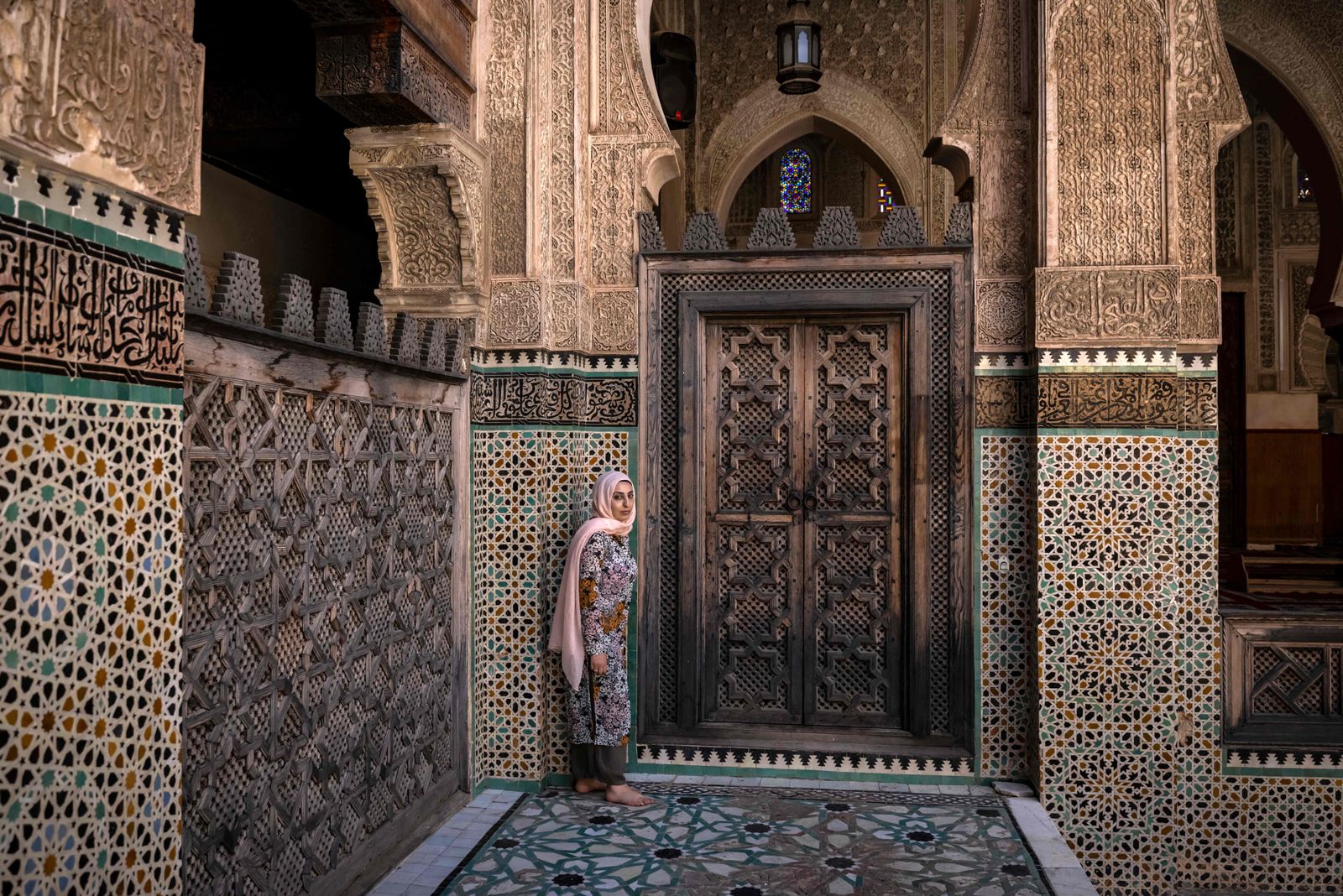 A woman visits the Bou Inania Madrasa, a theological school build between 1350 and 1355 AD, in the ancient Moroccan city of Fez on June 8, 2022. - Today, Fez serves as a monument to a highpoint of Islamic civilisation, the 13th and 14th centuries when Muslim rulers governed from Morocco to western China. (Photo by FADEL SENNA / AFP) - AFP