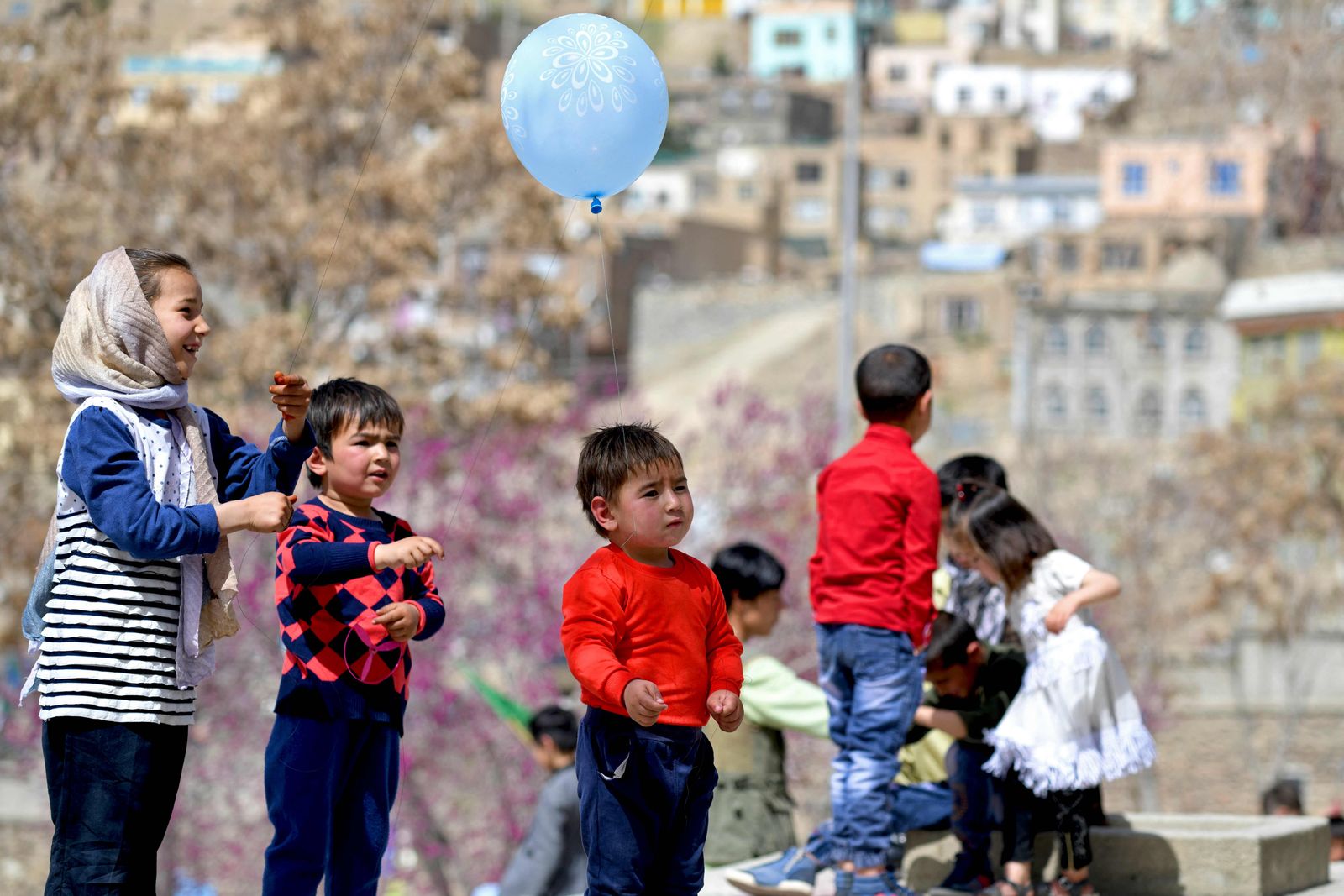 Children play in front of the Karte Sakhi shrine on the first day of 'Nowruz' marking the Persian New Year in Kabul on March 21, 2022. (Photo by Ahmad SAHEL ARMAN / AFP) - AFP