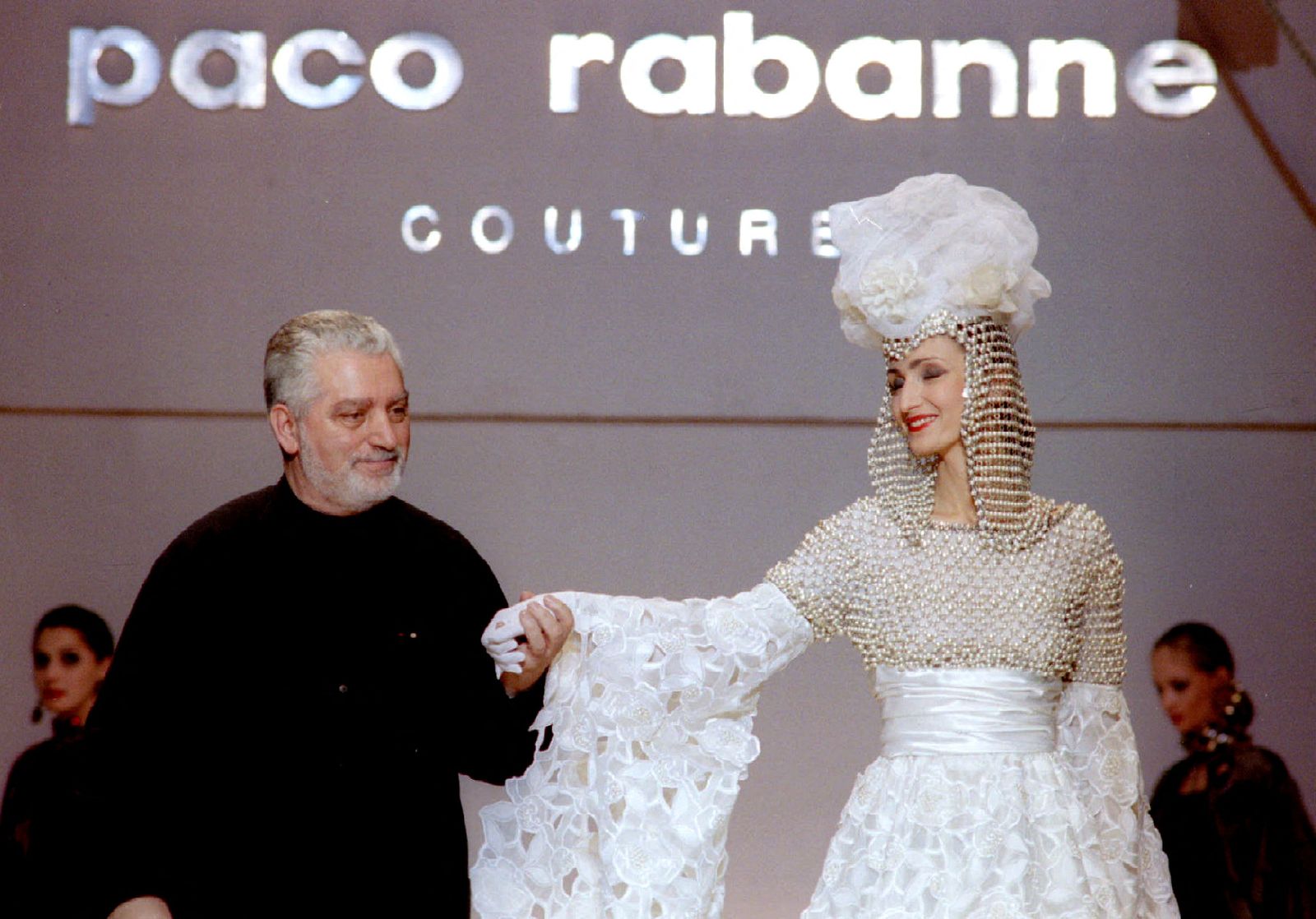 FILE PHOTO: French Fashion designer Paco Rabanne stands with one of his models at the finale of his show at the Rossiya Hotel in Moscow, November 25. STR New/File Photo - X80002