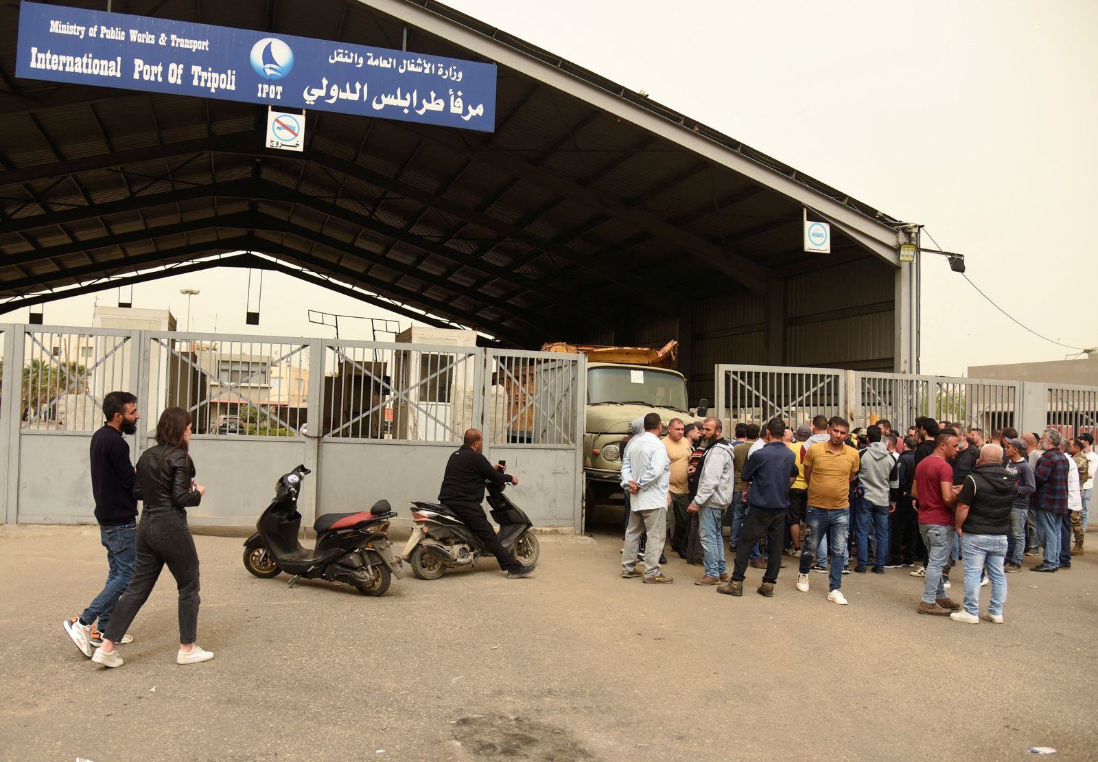 Relatives of people who died when a boat capsized off the Lebanese coast of Tripoli overnight, gather at the entrance of port of Tripoli - REUTERS