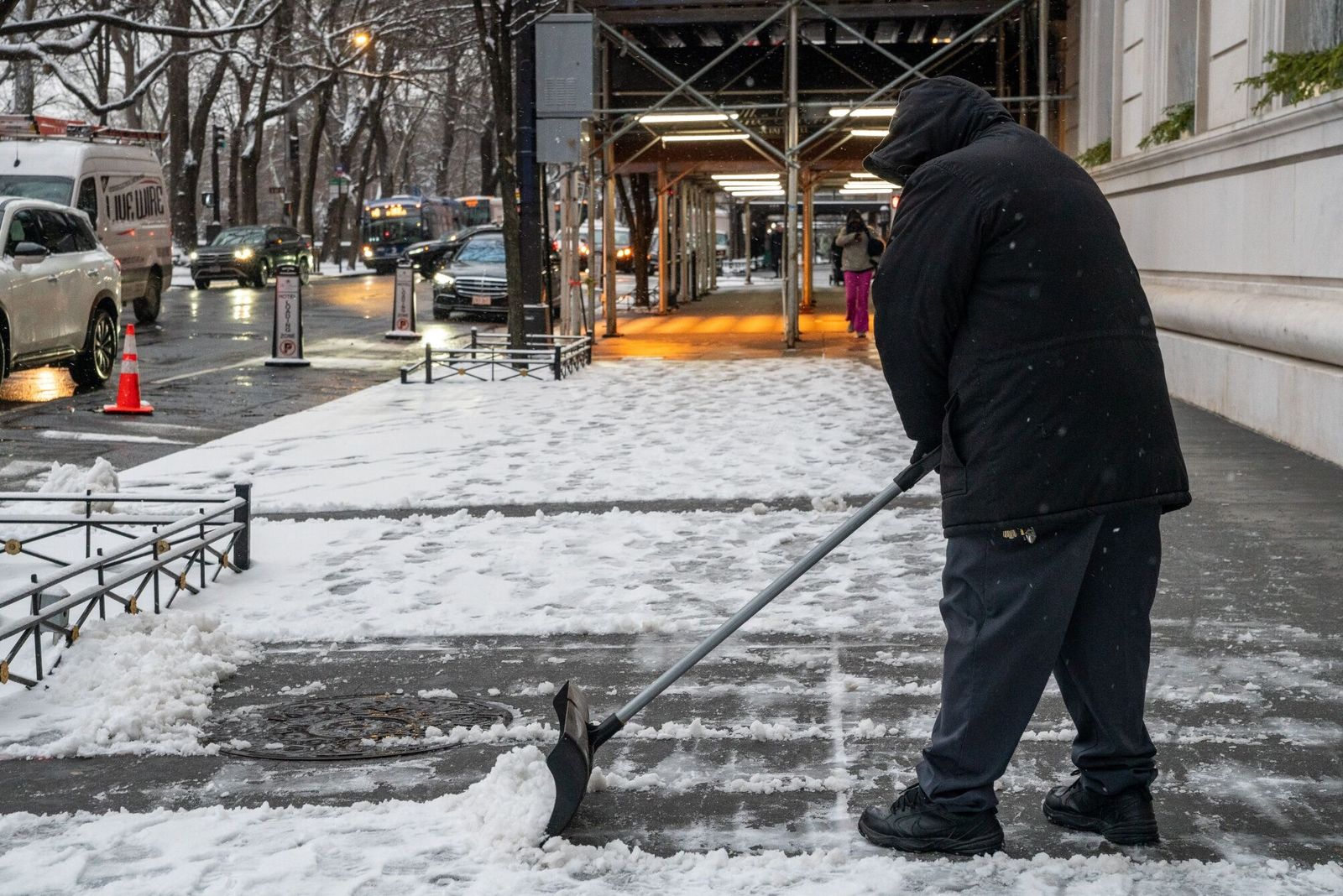 A worker clears snow from the sidewalk during a snow storm in New York, US, on Tuesday, Jan. 16, 2024. New York's Central Park is forecast to get 2 to 3 inches of snow starting late Monday into early Tuesday, breaking its longest snow-drought record as the winter storm freezing the central US moves east overnight. Photographer: David Dee Delgado/Bloomberg