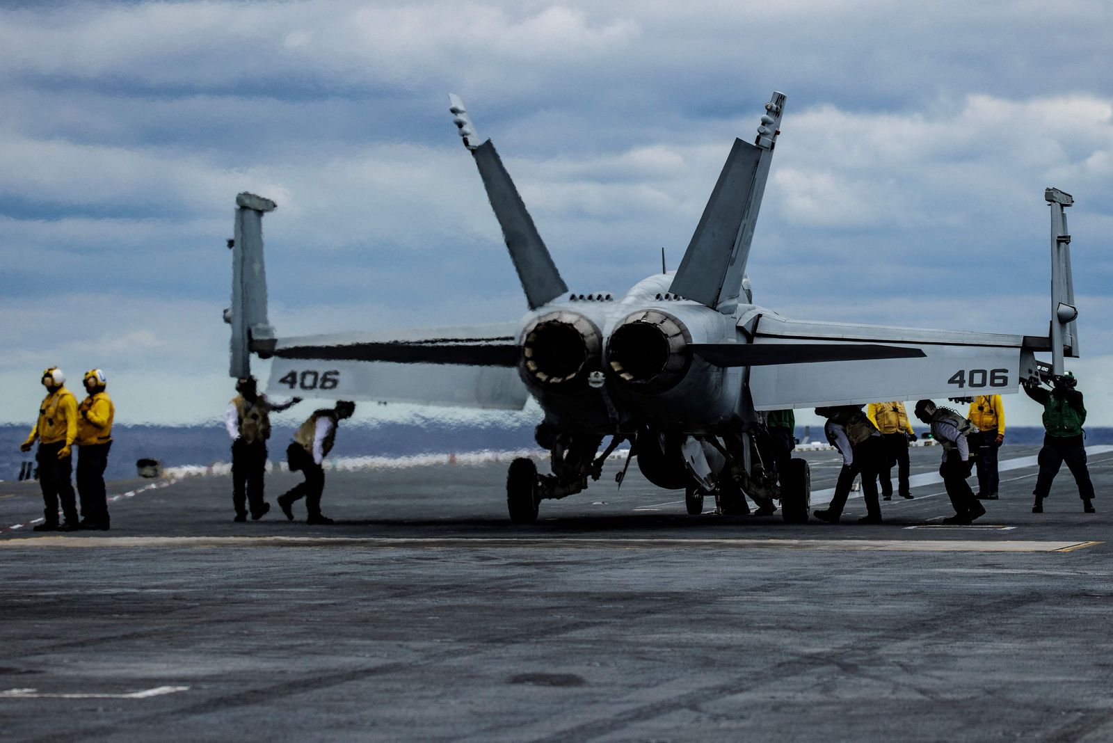 Sailors check a F/A-18E Super Hornet from Strike Fighter Squadron 87 after it lands on the flight deck of the USS Gerald Ford in the Atlantic Ocean off the coast of the US on October 6, 2022. - The USS Gerald Ford is the first new aircraft carrier to be designed in 40 years and and is the worlds largest and most expensive warship ever built. The Ford took 14 years to build and test and is fitted with 23 new technologies including an Electromagnetic Aircraft Launch System (EMALS) and Advance Weapons Elevators (AWE�s). (Photo by Samuel Corum / AFP)