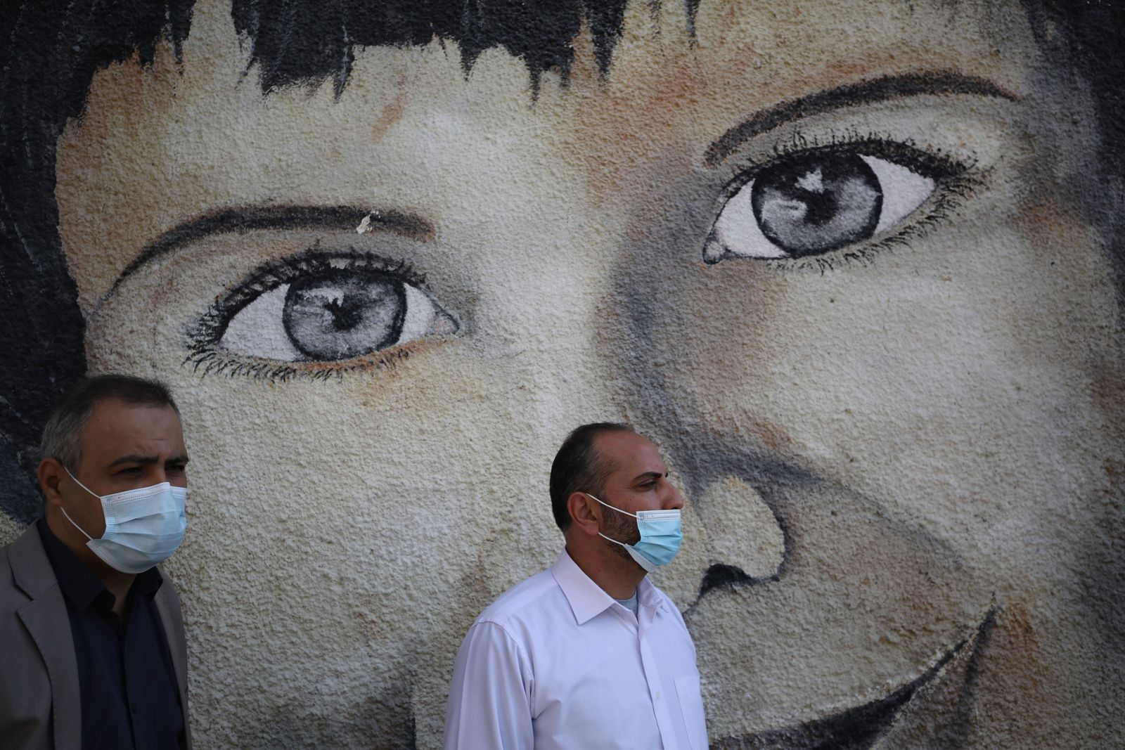 Palestinian UNRWA emplyees, mask-clad due to the COVID-19 coronavirus pandemic, protest outside the headquarters of the United Nations Relief and Works Agency for Palestine Refugees in the Near East (UNRWA) in Gaza City on November 17, 2020 against the reduction of their salaries. - financial crisis