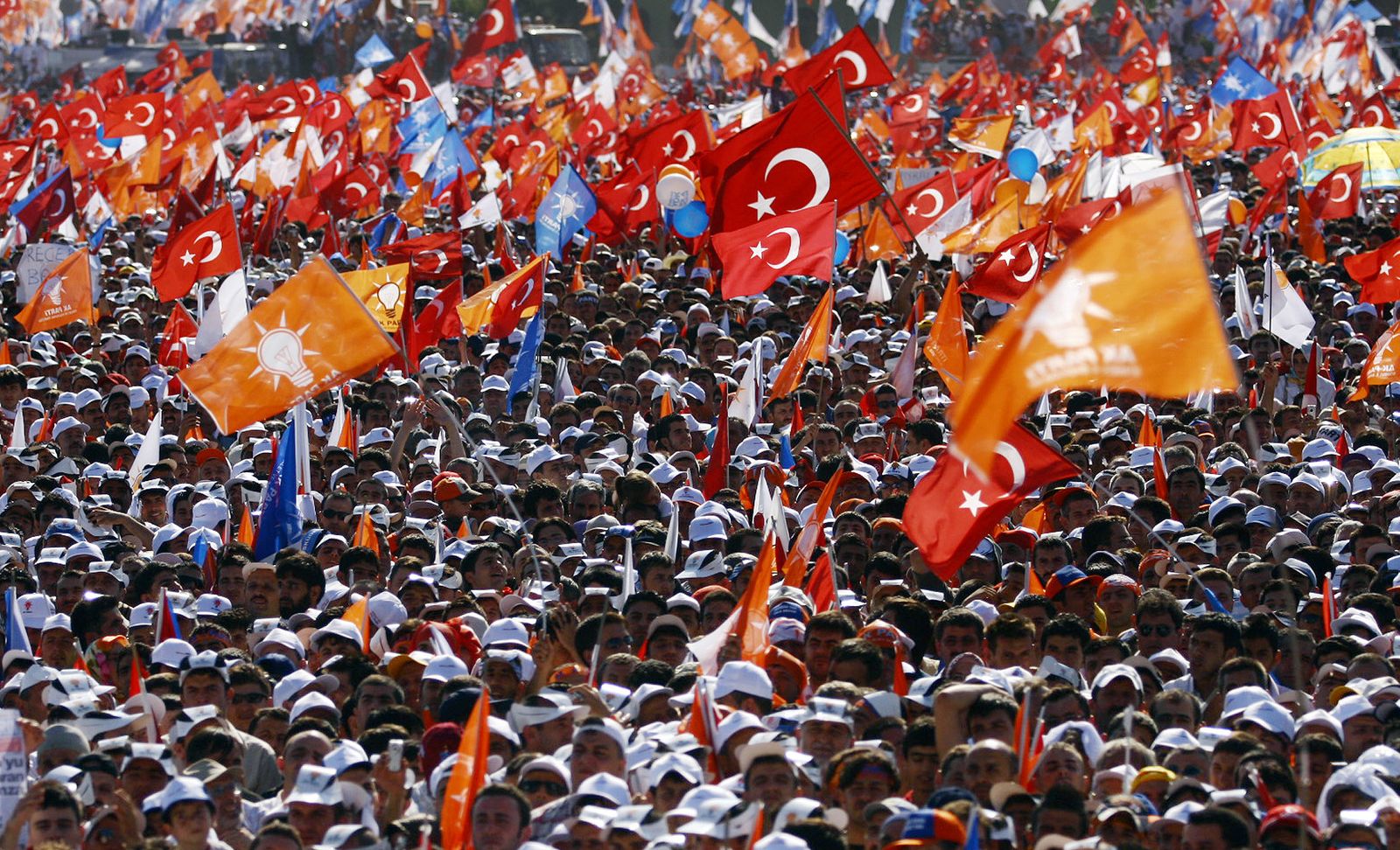 أنصار حزب العدالة والتنمية في تركيا يلوحون بعلمي تركيا والحزب خلال تجمع انتخابي في إسطنبول، 15 يوليو 2007 - AFP