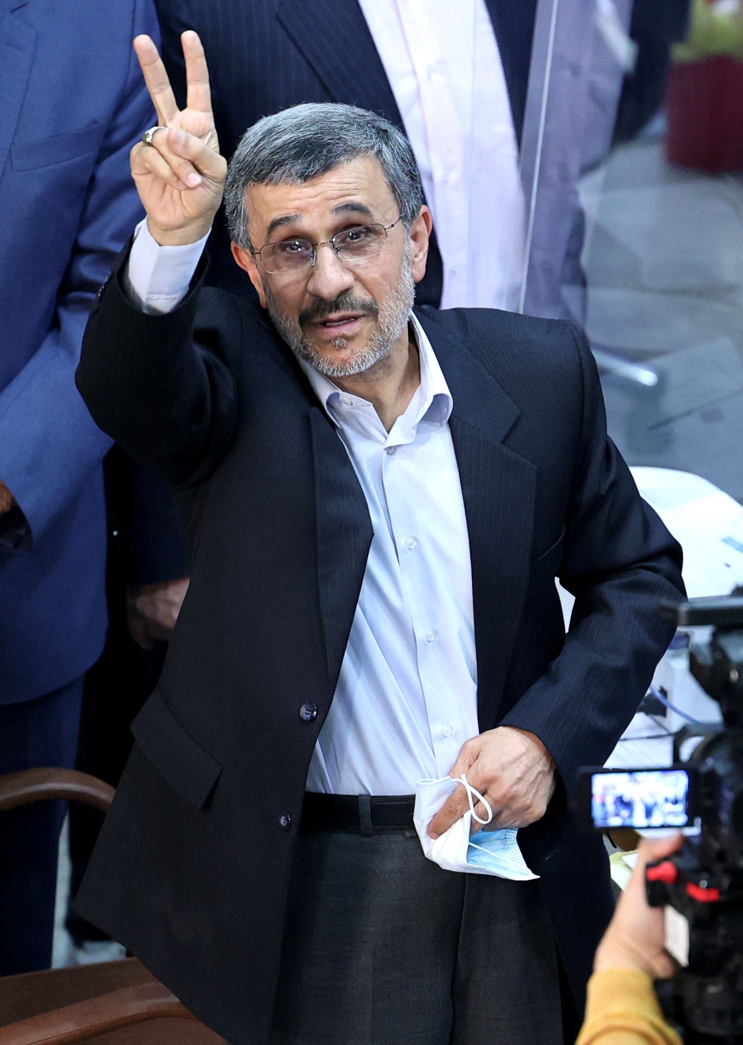 Iranian presidential candidate and former president Mahmoud Ahmadinejad flashes the victory sign as he registers his candidacy for the post of president of Iran, at the Interior Ministry in Tehran on May 12, 2021. - Iranian hopefuls threw their hats into the ring on May 11, launching the battle to succeed moderate President Hassan Rouhani in June 18 elections. (Photo by ATTA KENARE / AFP) - AFP