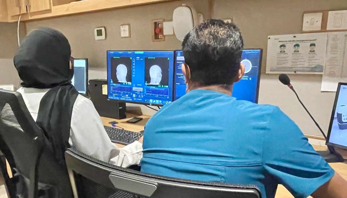 فنيان يتابعان العملية الجراحية الإشعاعية عبر شاشة مراقبة. - وكالة أنباء عمان