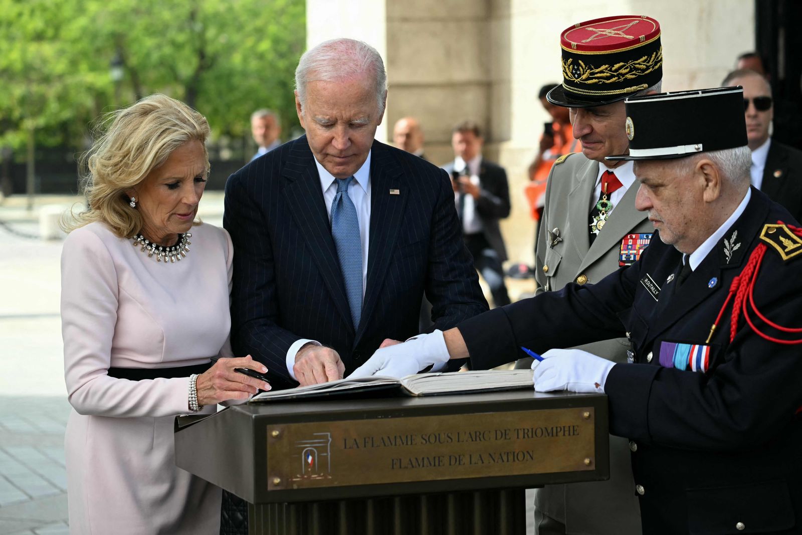 US President Joe Biden (C), flanked by US First Lady Jill Biden (L), participates in a ceremony as part of a state visit to France, at the Arc de Triomphe in Paris on June 8, 2024. Biden is due to meet Macron for talks at the Elysee Palace in Paris followed by a state banquet given in his honour, with Ukraine's battle against the Russian invasion the dominant topic. (Photo by SAUL LOEB / AFP)