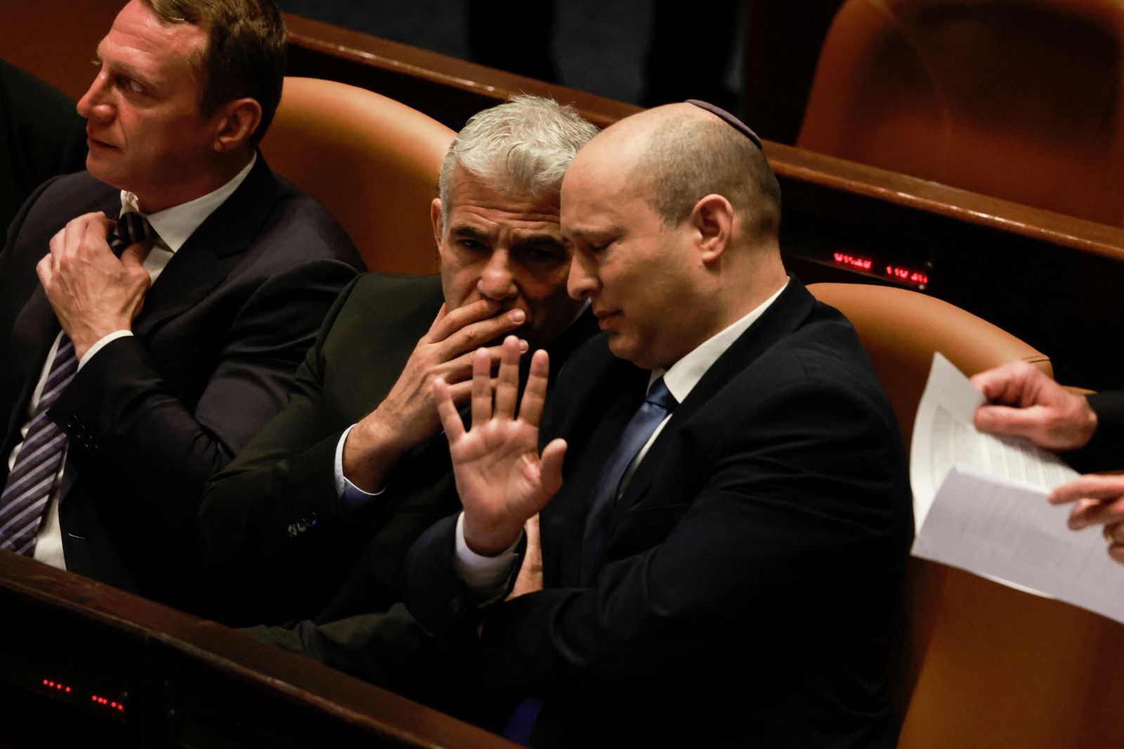 Israeli Minister of Foreign Affairs Yair Lapid (R) and outgoing Prime Minister Naftali Bennett, speak to each other at the Knesset (parliament), following the dissolution of the parliament, in Jerusalem on June 30, 2022. - Israeli lawmakers dissolved parliament today, forcing the country's fifth election in less than four years, with Foreign Minister Yair Lapid set to take over as caretaker prime minister at midnight. The final dissolution bill, which passed with 92 votes in favour none against, ends the year-long premiership of Naftali Bennett, who led an eight-party coalition that was backed by an Arab party, a first in Israeli history. (Photo by Menahem KAHANA / AFP) - AFP
