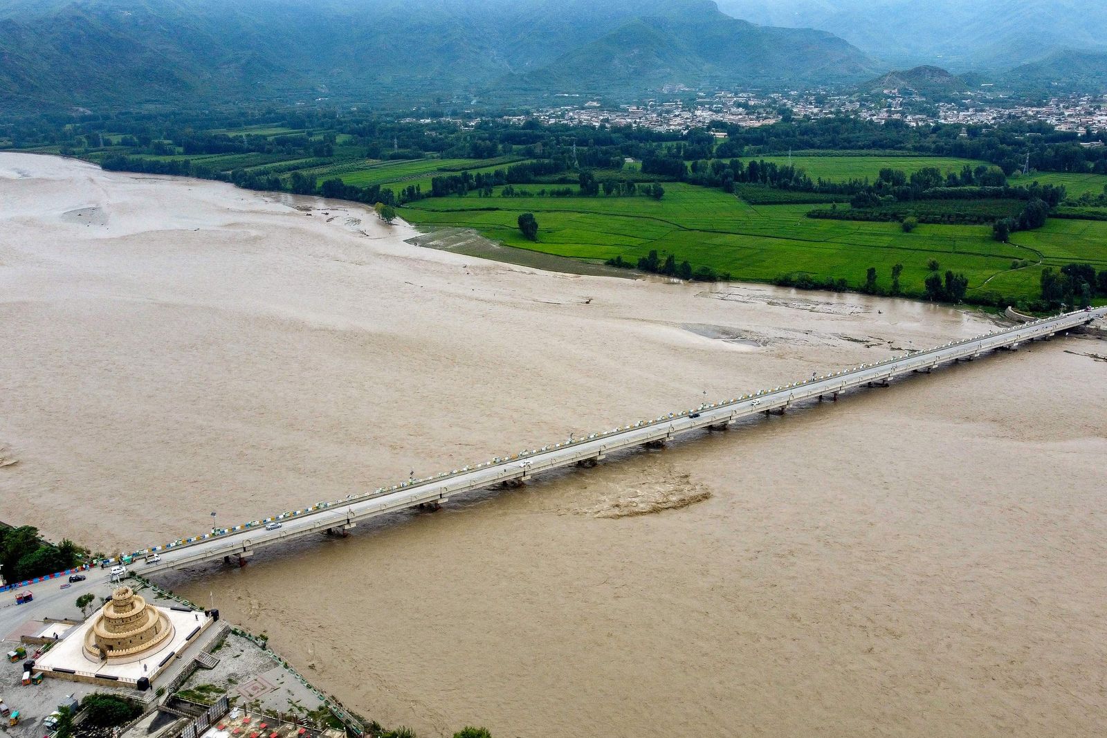 This aerial view of flooding is pictured in Mingora, a town in the Pakistan's northern Swat Valley following heavy monsoon rainfall on August 27, 2022. - Thousands of people living near flood-swollen rivers in Pakistan's north were ordered to evacuate on August 27 as the death toll from devastating monsoon rains neared 1,000 with no end in sight to the deluge. (Photo by Abdul MAJEED / AFP) - AFP