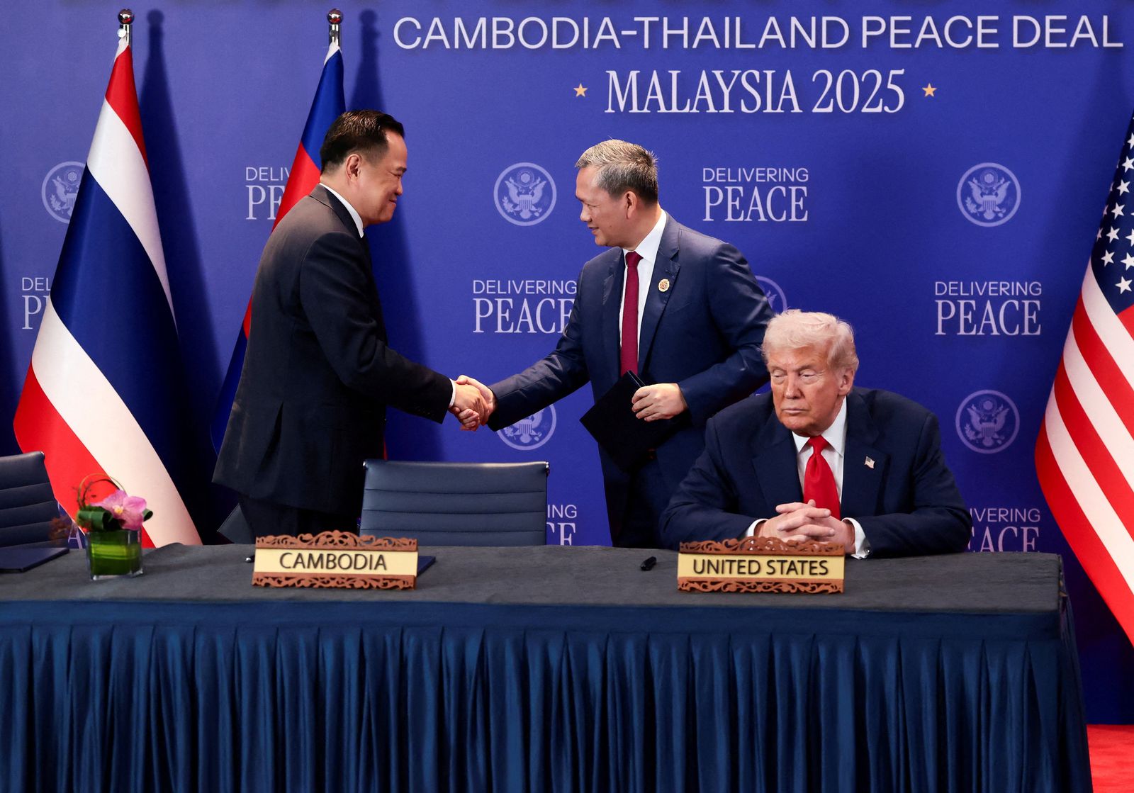 Thailand's Prime Minister Anutin Charnvirakul and Cambodia’s Prime Minister Hun Manet shake hands next to U.S. President Donald Trump, on the day of the signing of a ceasefire deal between Cambodia and Thailand on the sidelines of the 47th Association of Southeast Asian Nations (ASEAN) summit in Kuala Lumpur, Malaysia, October 26, 2025. REUTERS/Evelyn Hockstein     TPX IMAGES OF THE DAY
