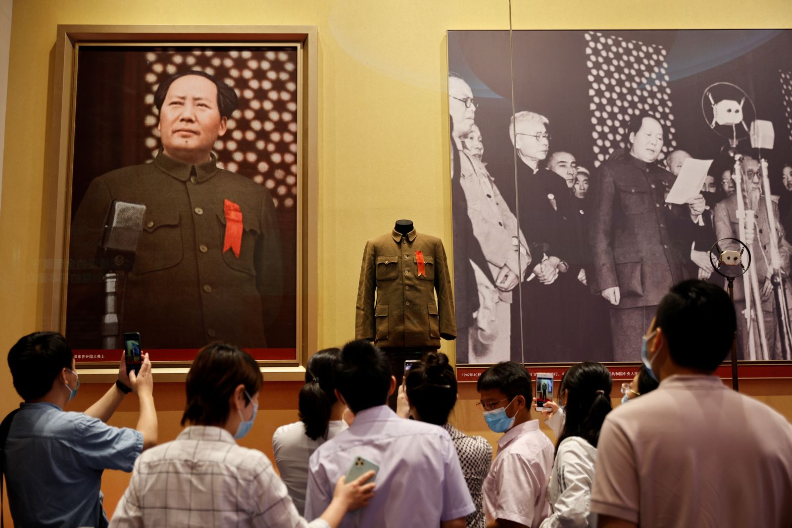 ينظرون إلى صورتين للزعيم الصيني ماو تسي تونغ في متحف للحزب الشيوعي ببكين - 25 يونيو 2021 - REUTERS